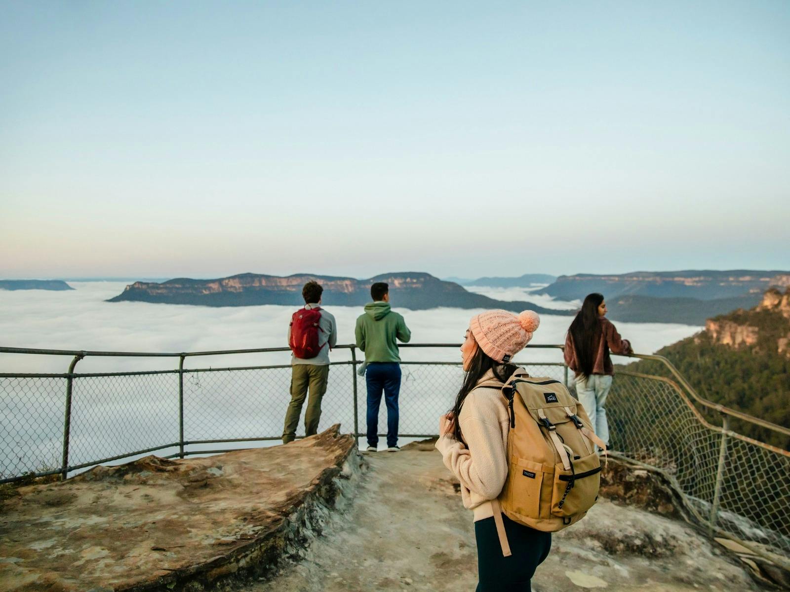 Tourists taking in the scenic view of the sea and surrounding mountains