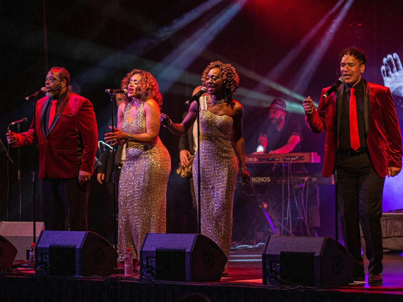 four people singing on stage