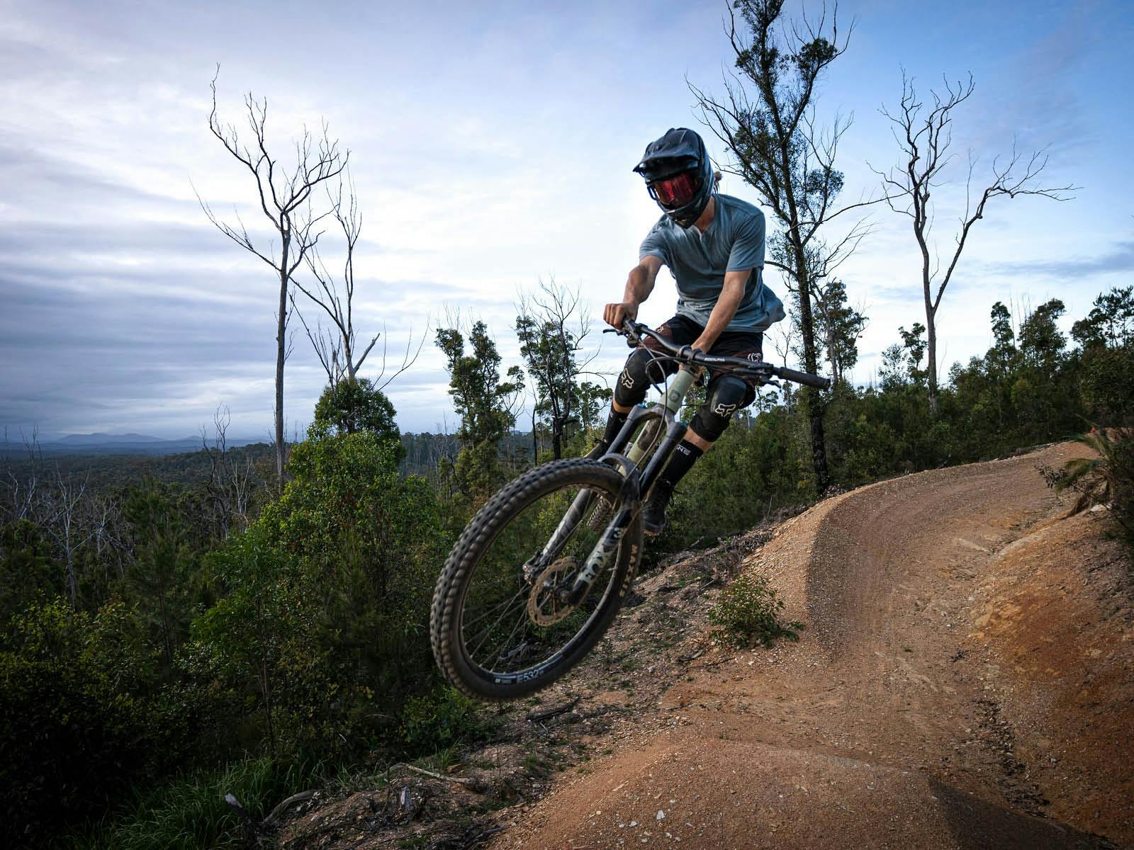 숲 속의 비포장 도로를 달리는 자전거 타는 사람