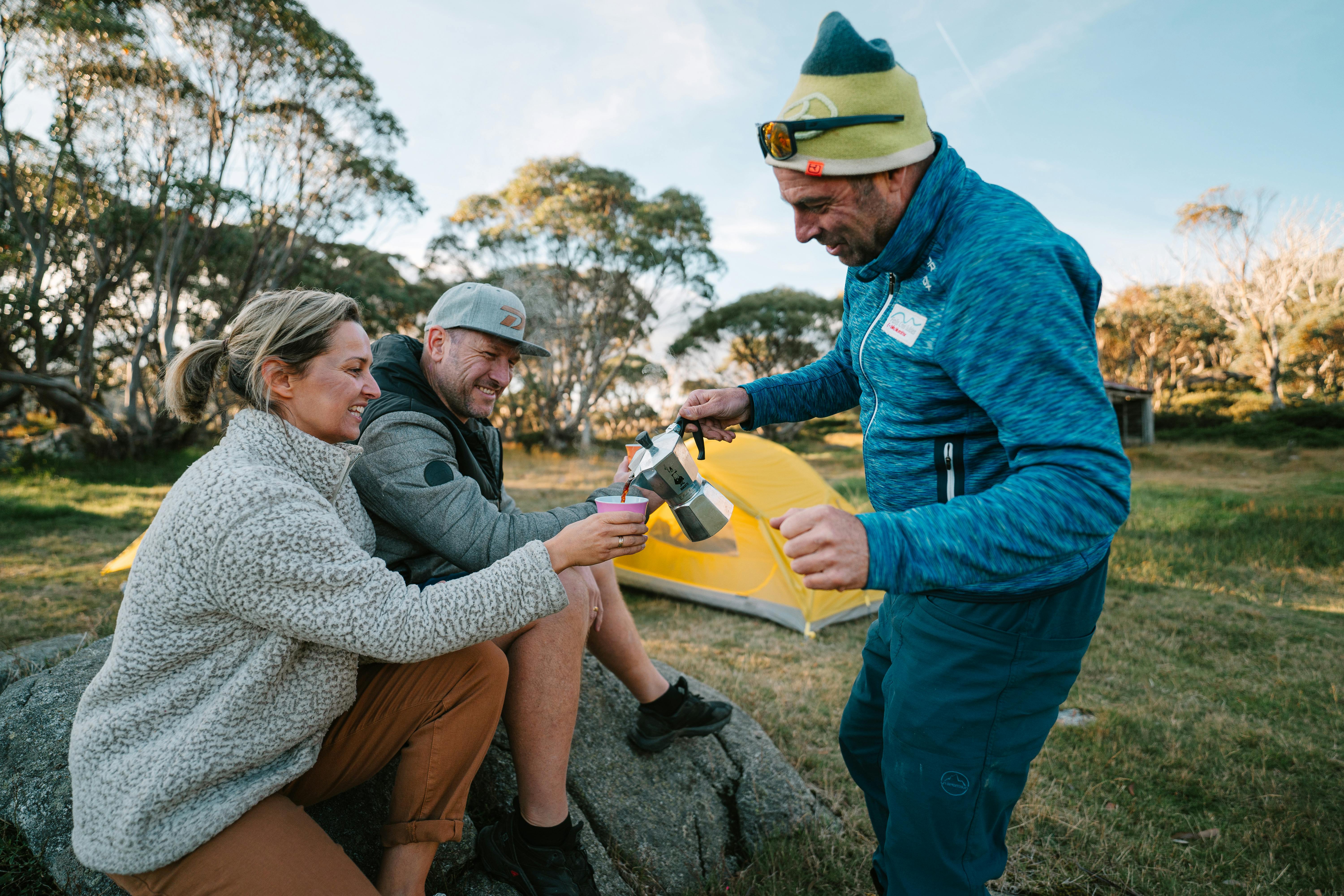 Man pouring coffee in a cup for a woman