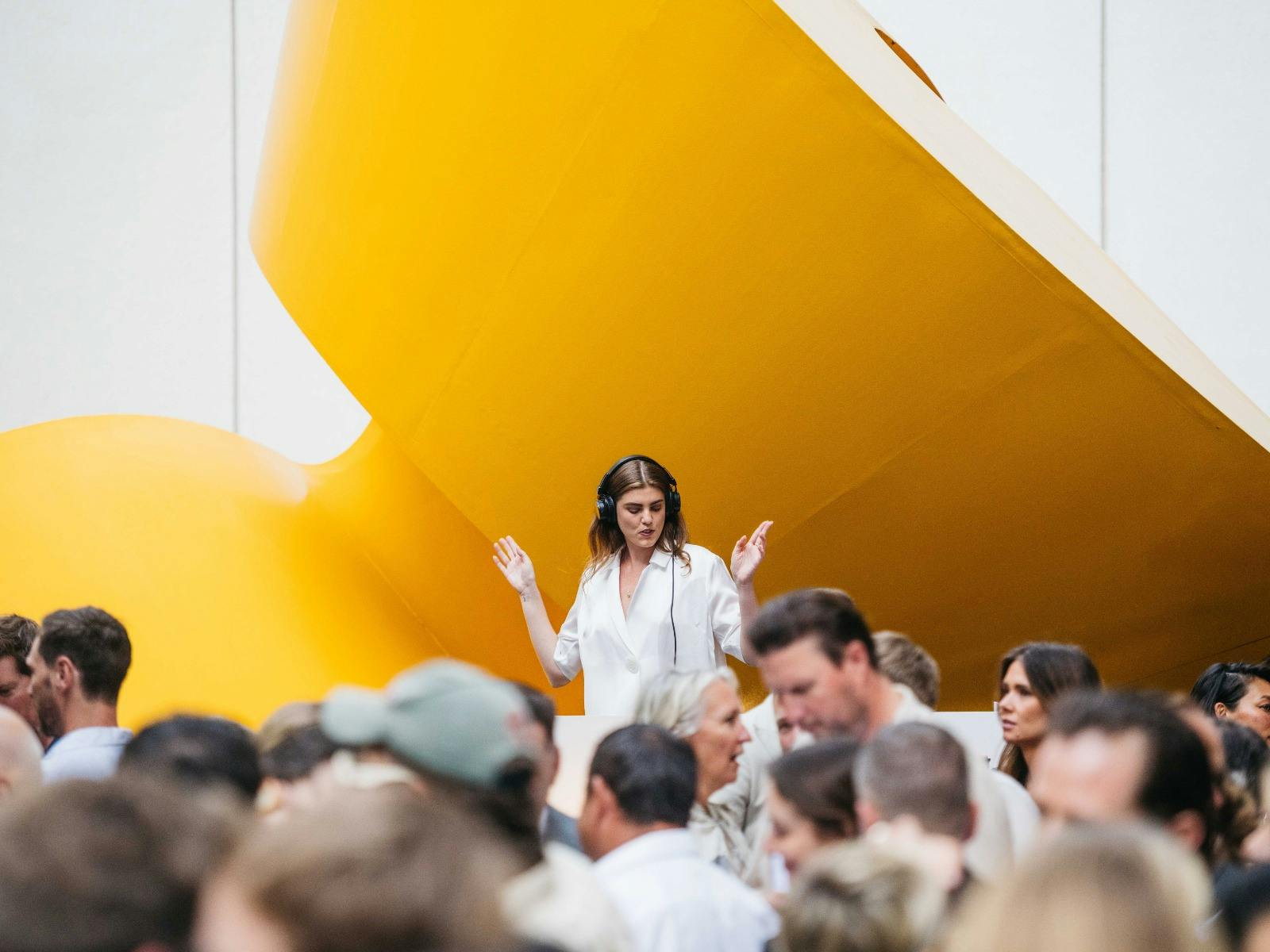 DJ in front of yellow sculpture