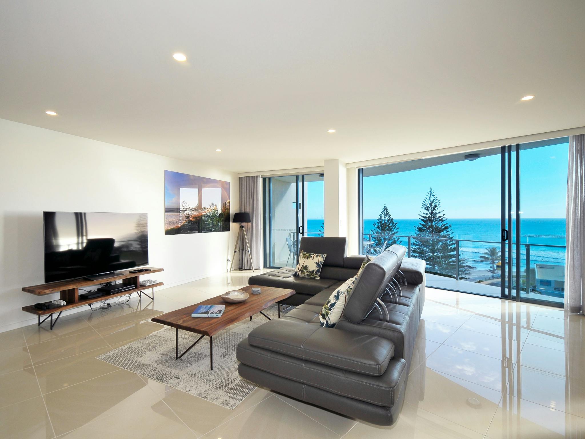 Contemporary lounge with high-gloss neutral tiles, brown leather sofa, and breathtaking ocean views Contemporary lounge with high-gloss neutral tiles, brown leather sofa, and breathtaking ocean views