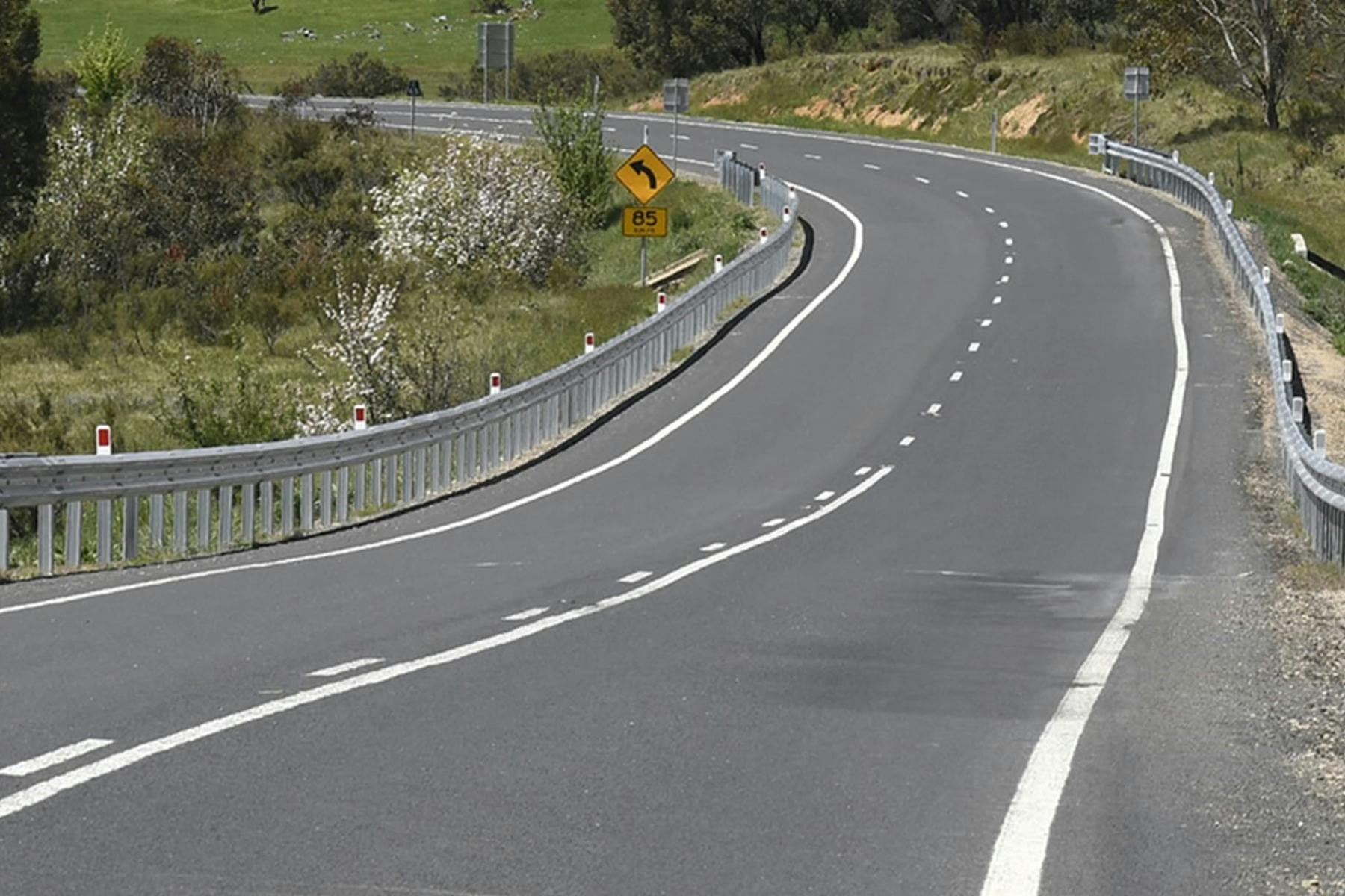 A curved road with wildflowers in the Snowy Mountains