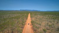 A car drives on an unsealed outback road near Mareeba, Tropical North Queensland.