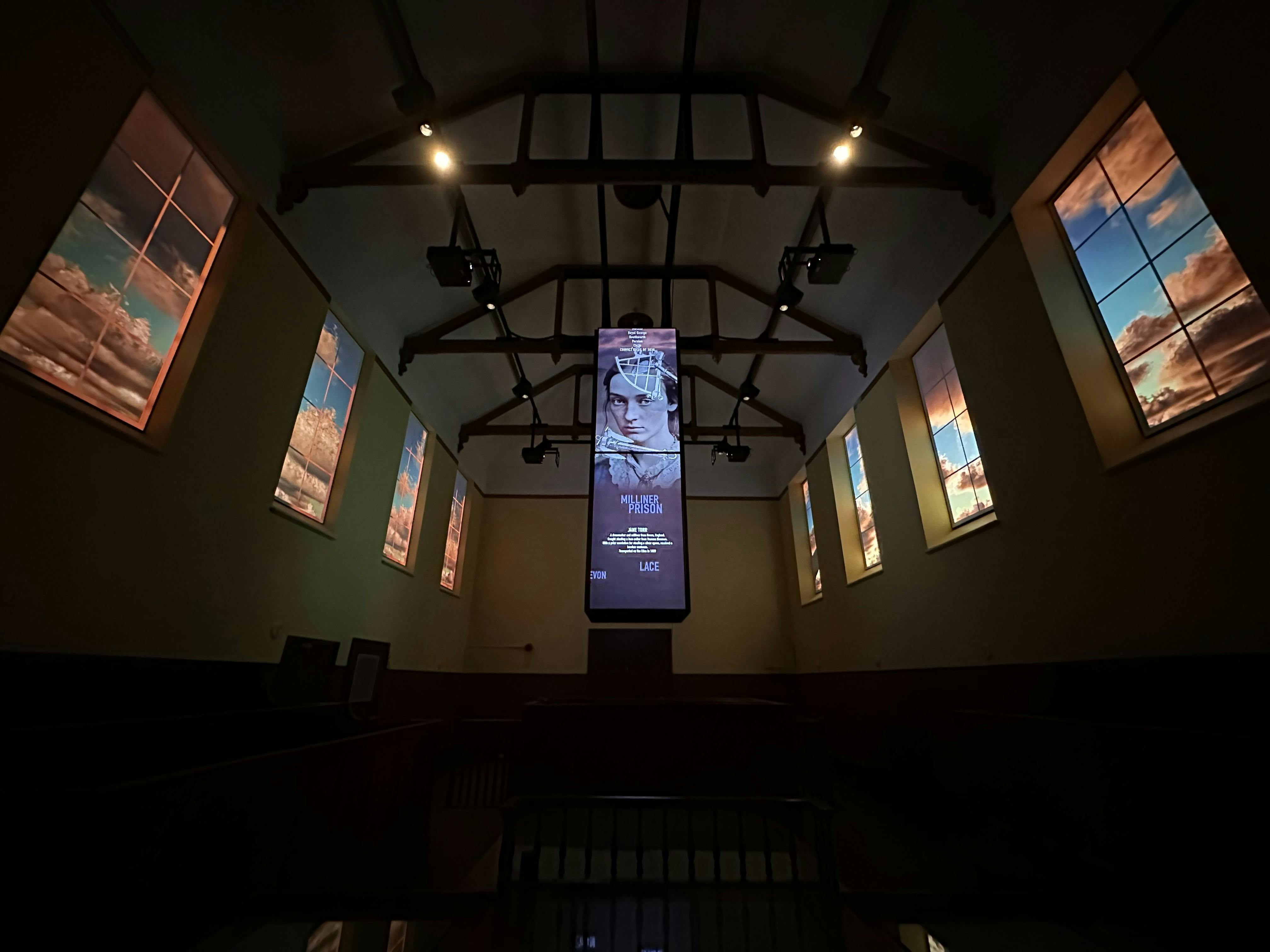 A column of screens suspended from the ceiling with lit up windows on each side of the room