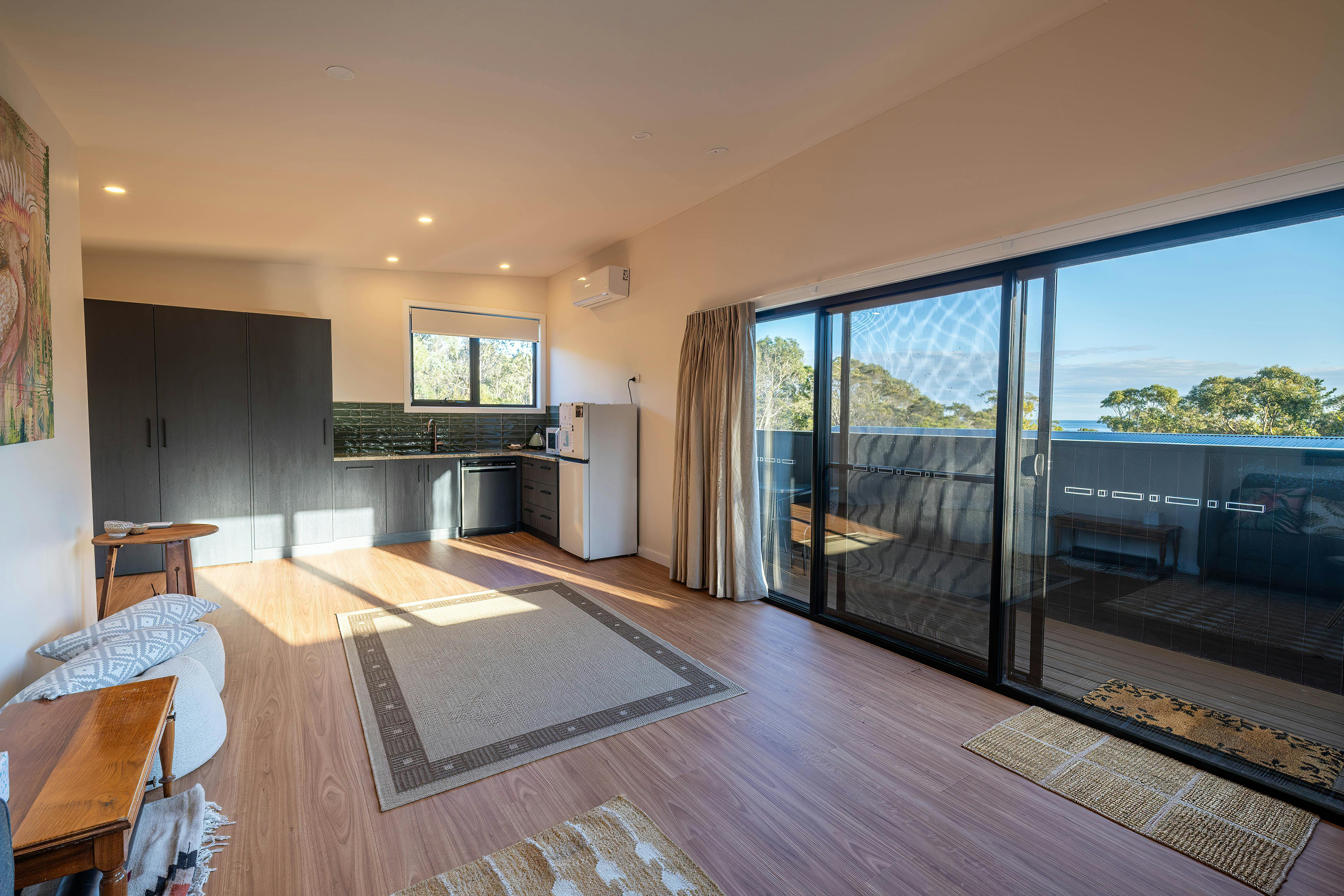 Living area with mat, sliding doors and kitchen