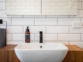 white tiled bathroom with timber vanity