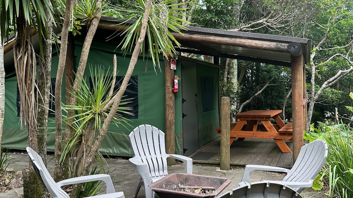 Image shows the exterior courtyard and fire pit of the Safari Tents Image shows the exterior courtyard and fire pit of the Safari Tents