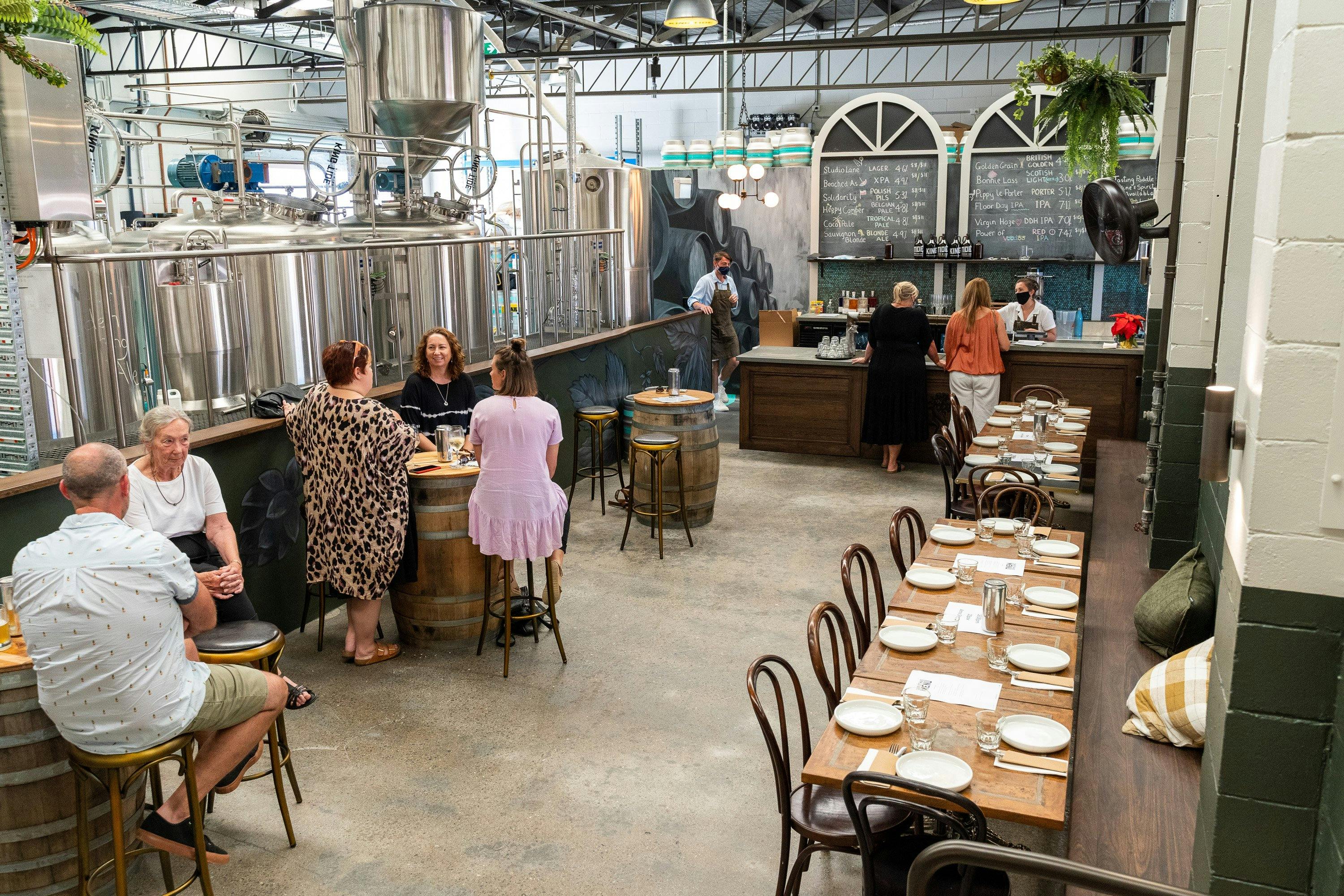 bar and brewery equipment with people sitting at the barrels