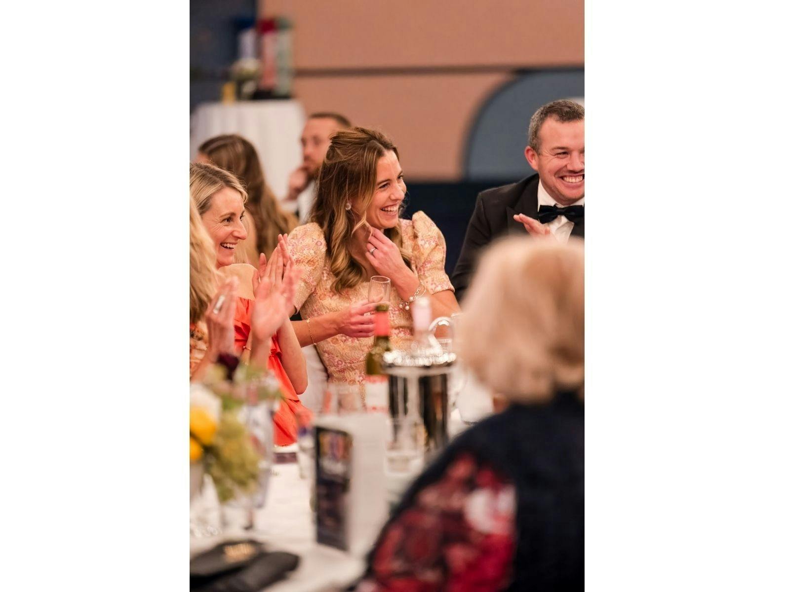 A group at a gala event having a laugh over a great story.