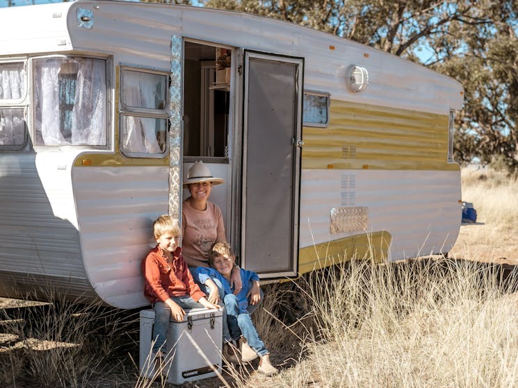 A family sitting in their Caravan at the Gilgooma camp ground farm stay in the rural paddock setting