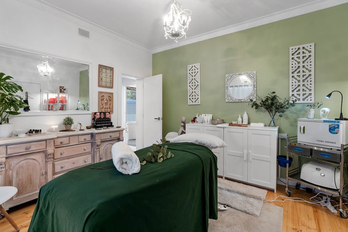 Shows a treatment room with a massage bed for a holistic healing experience