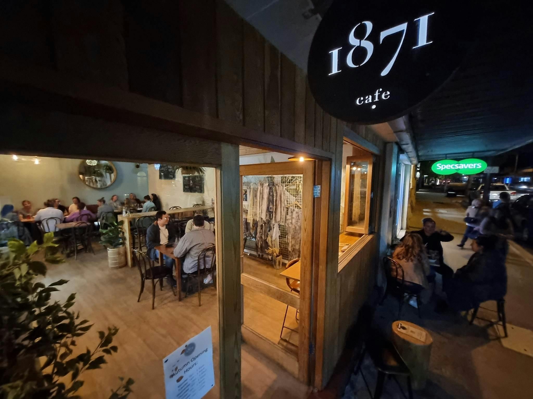 Dimmly lit bar with wooden furniture and people drinking beverages.