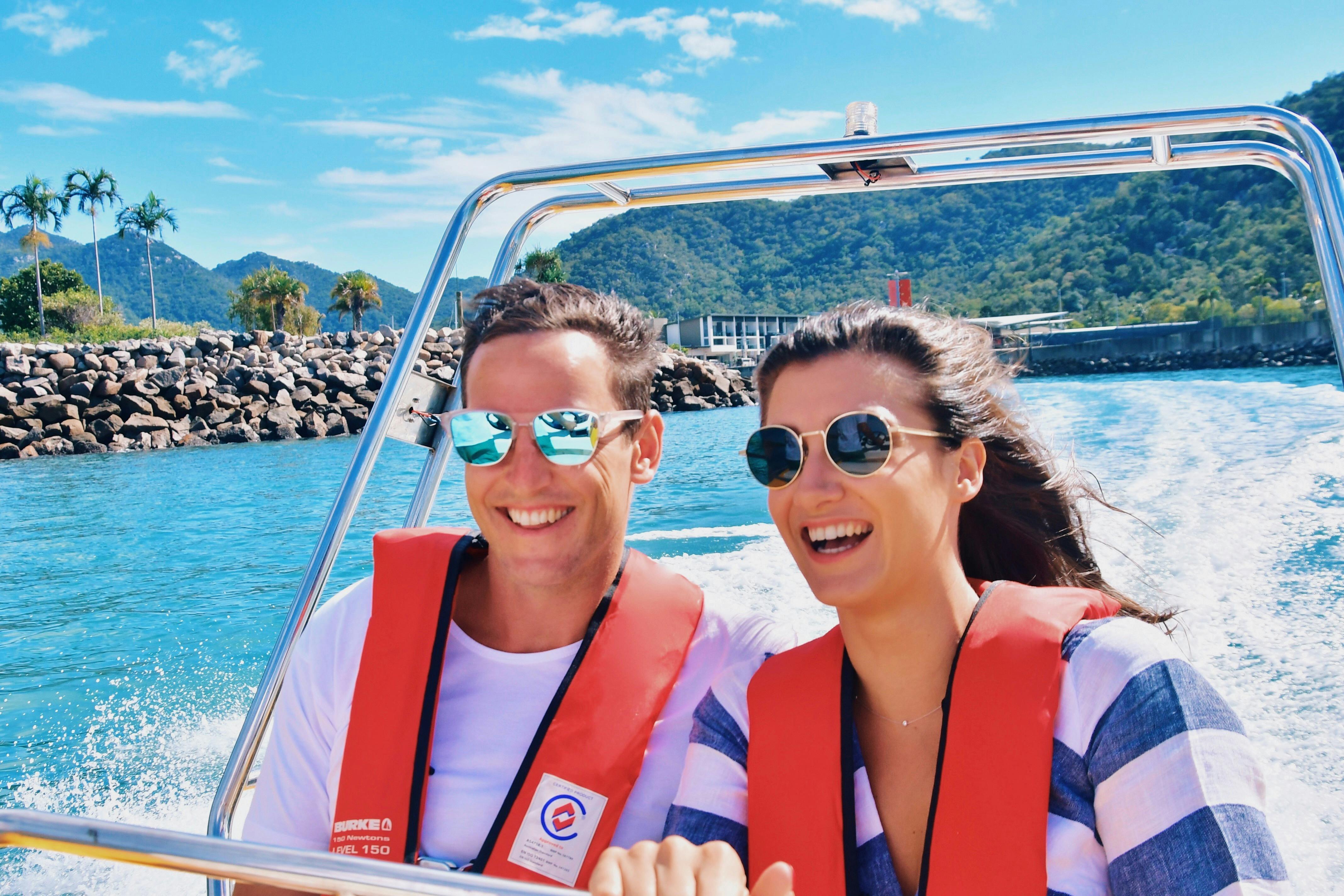 Couple on small fast boat with Magnetic Island in the background
