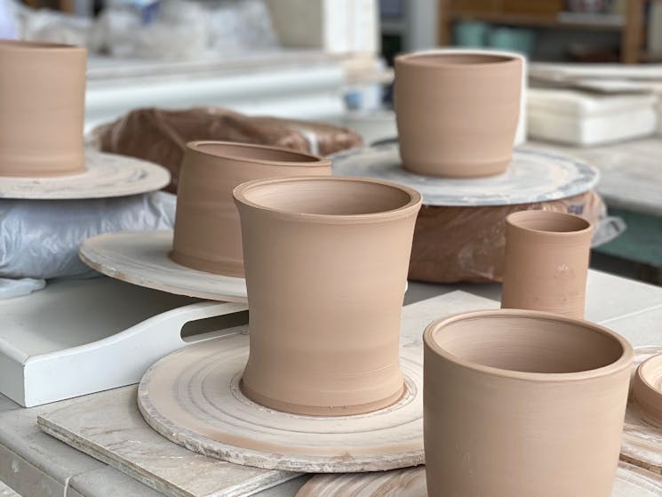 picture shows pottery on boards on a table