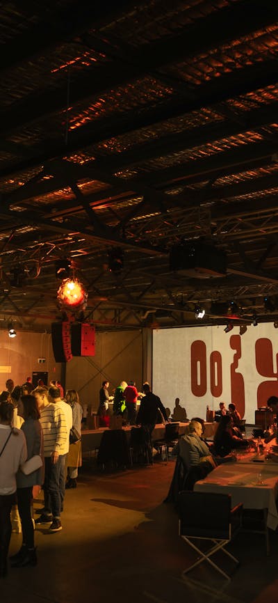 Large indoor space with cheese and wine stalls and seating with lots of people