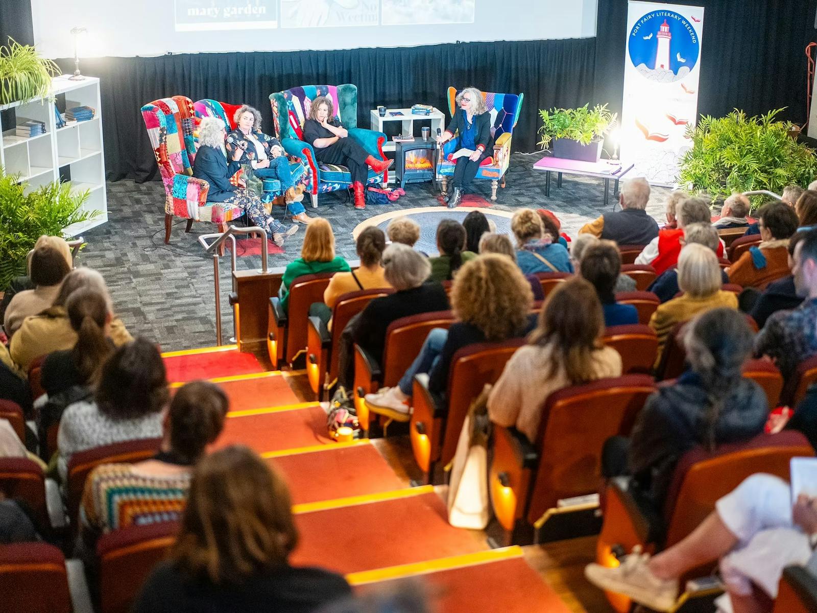 authors sitting on chairs on a stage and seated audience members facing them