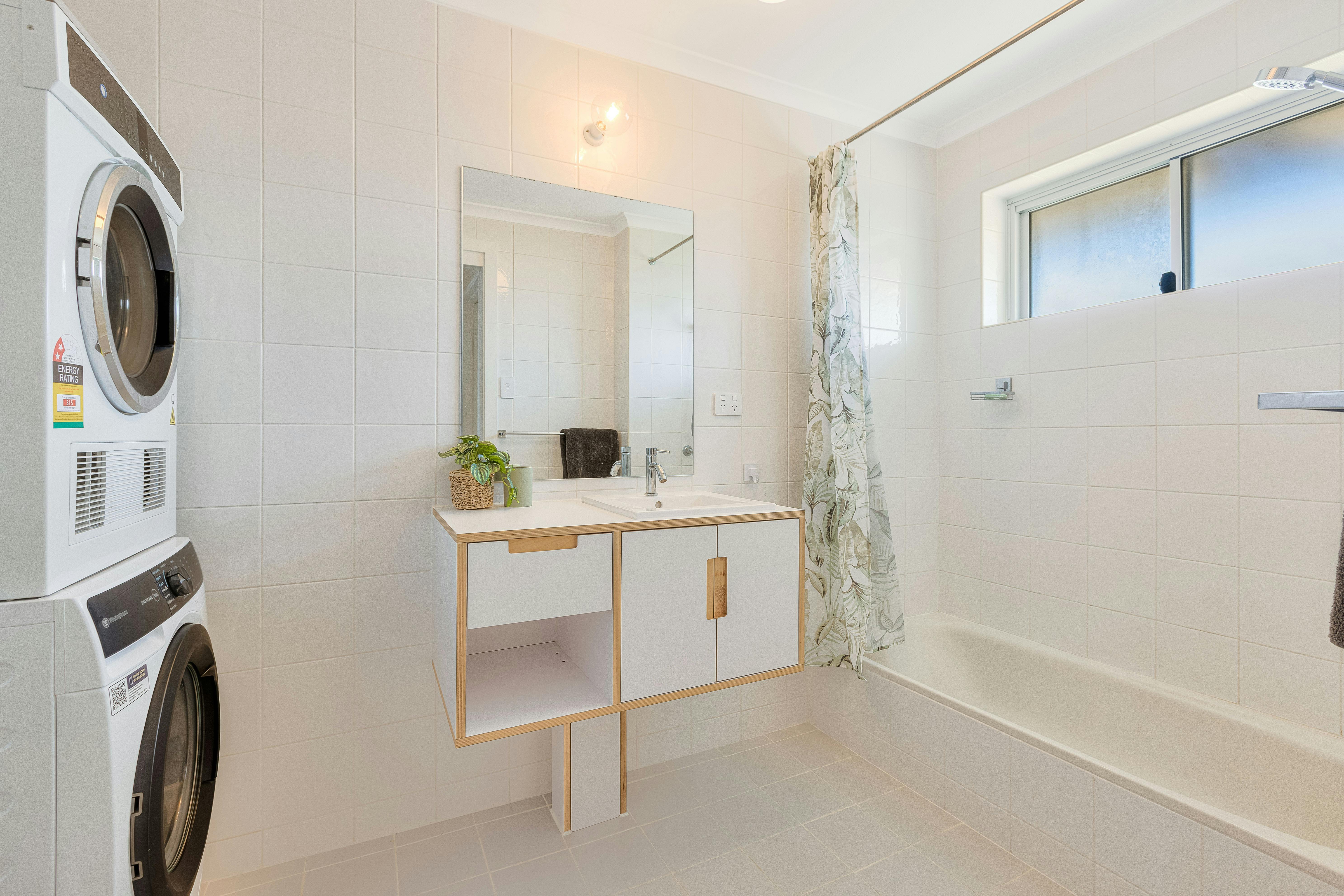 Main bathroom with shower over bath plus washng machine and dryer