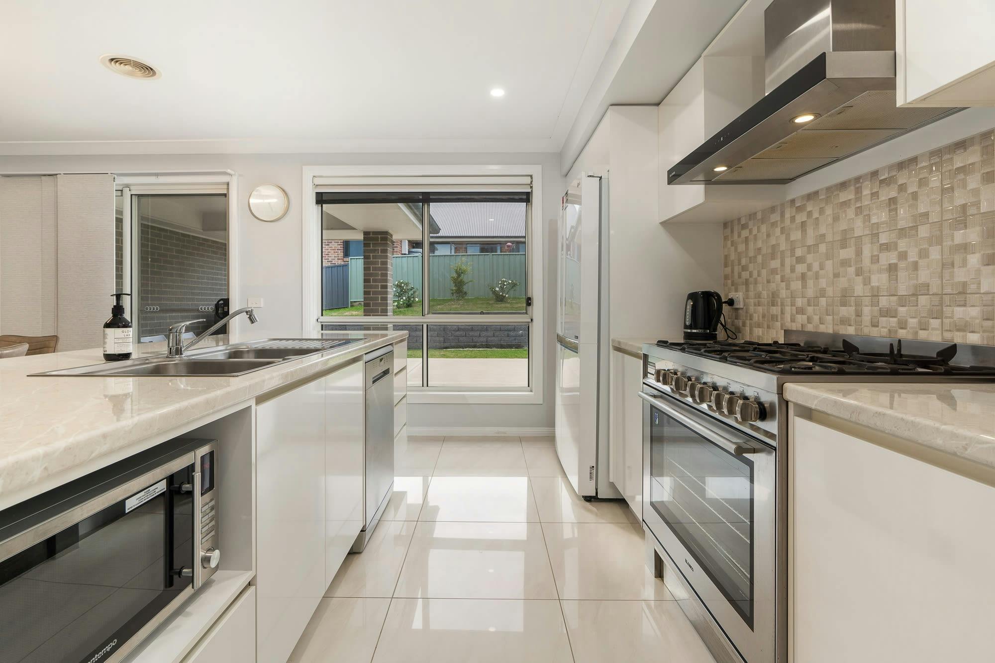 아일랜드 벤치 가전제품 및 편의 시설이 갖춰진 주방