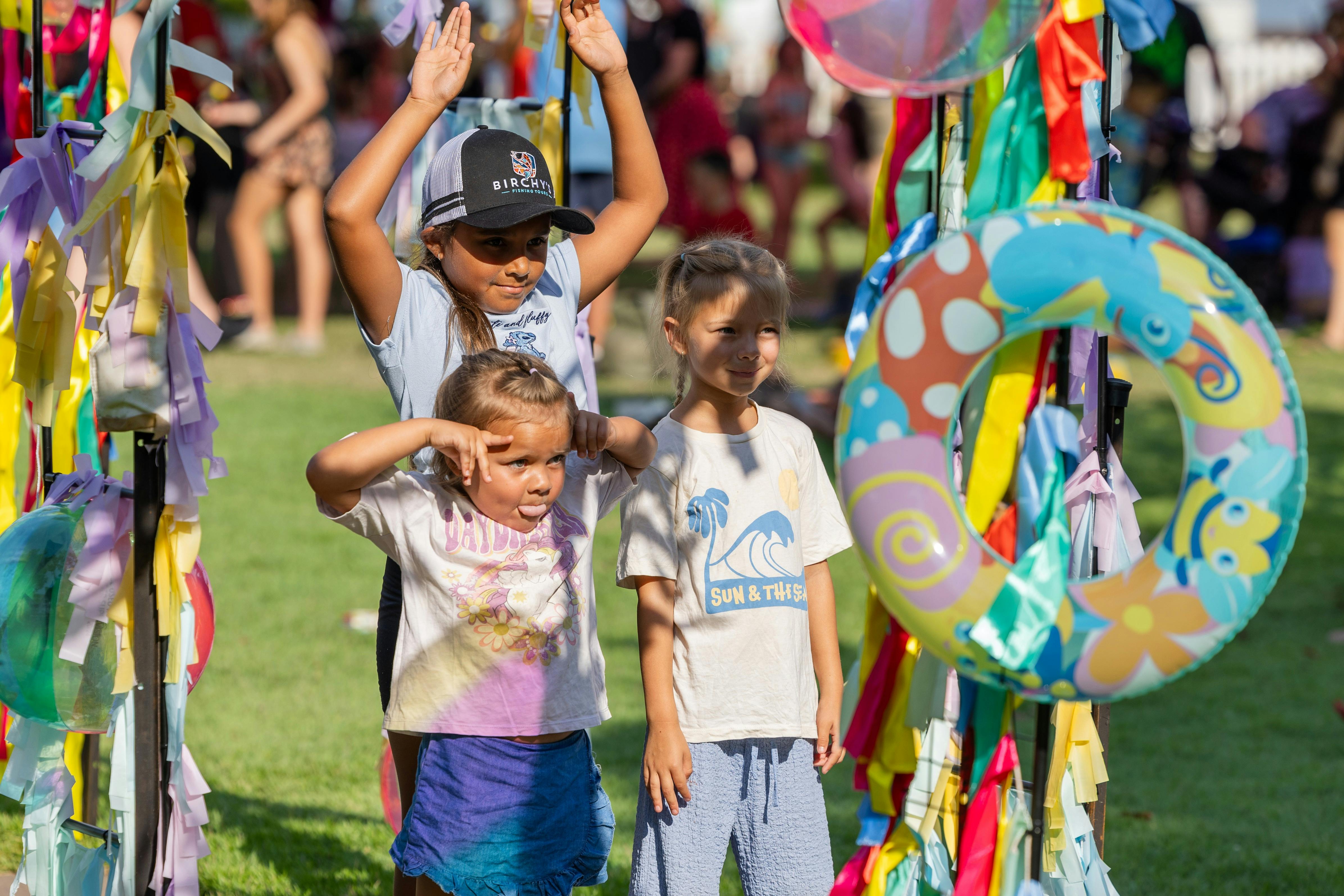 Children posing under a colourful arch