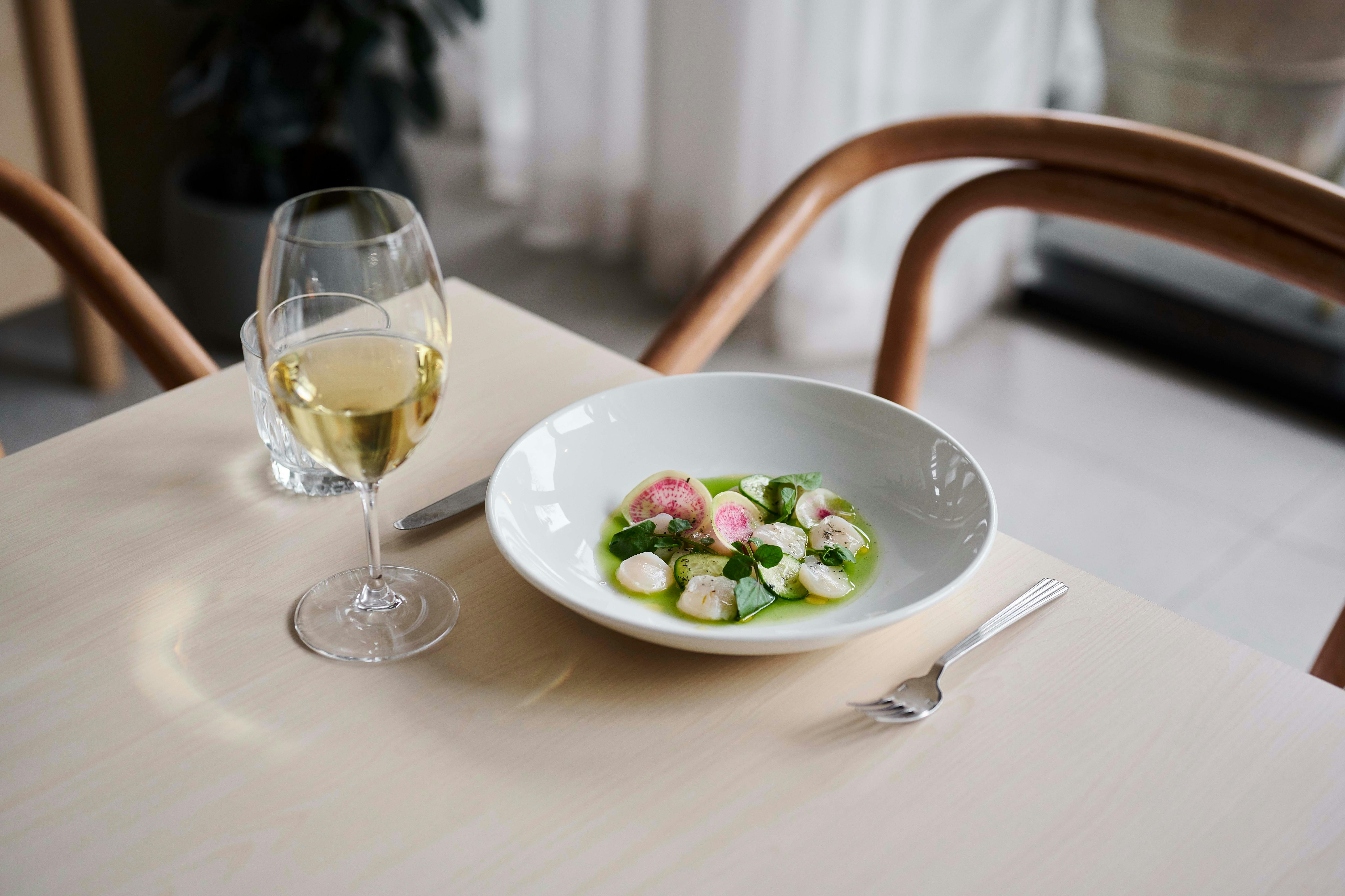 A dish of scallops and a glass of wine