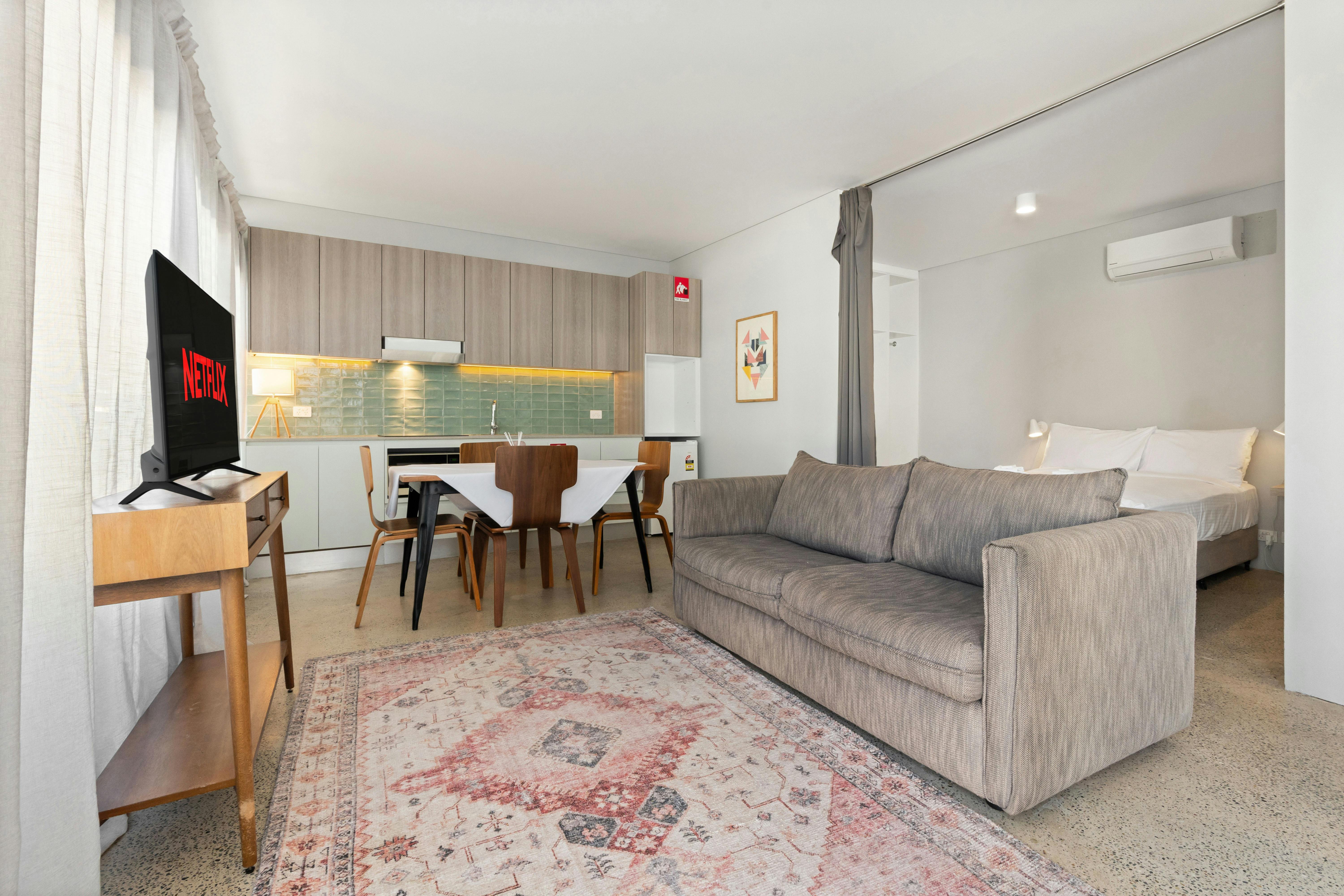 발코니에서 보이는 아파트 풍경에는 식사 공간 소파, TV가 있습니다.