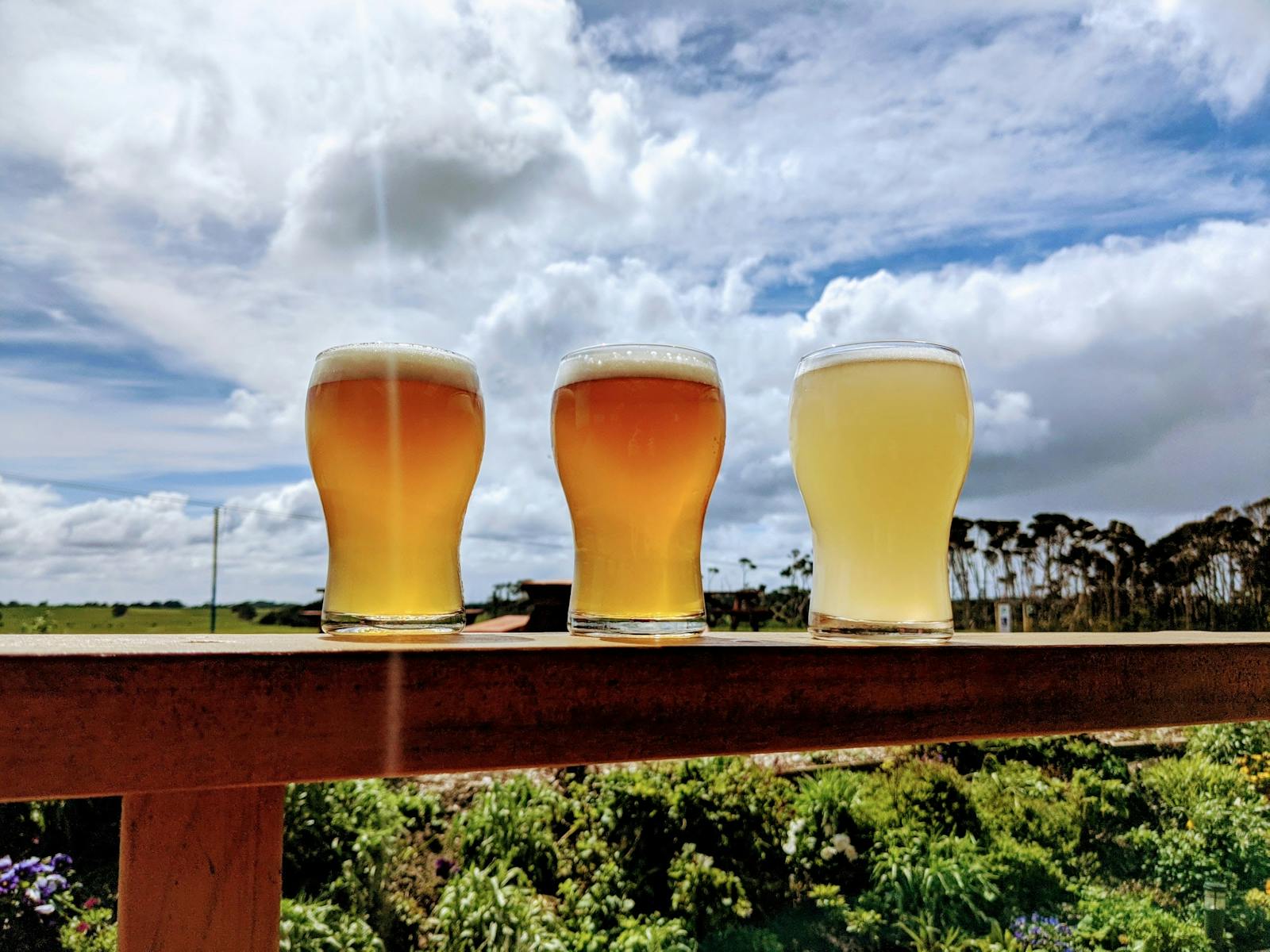 Three beer on the rail of a deck at King Island Brewhouse