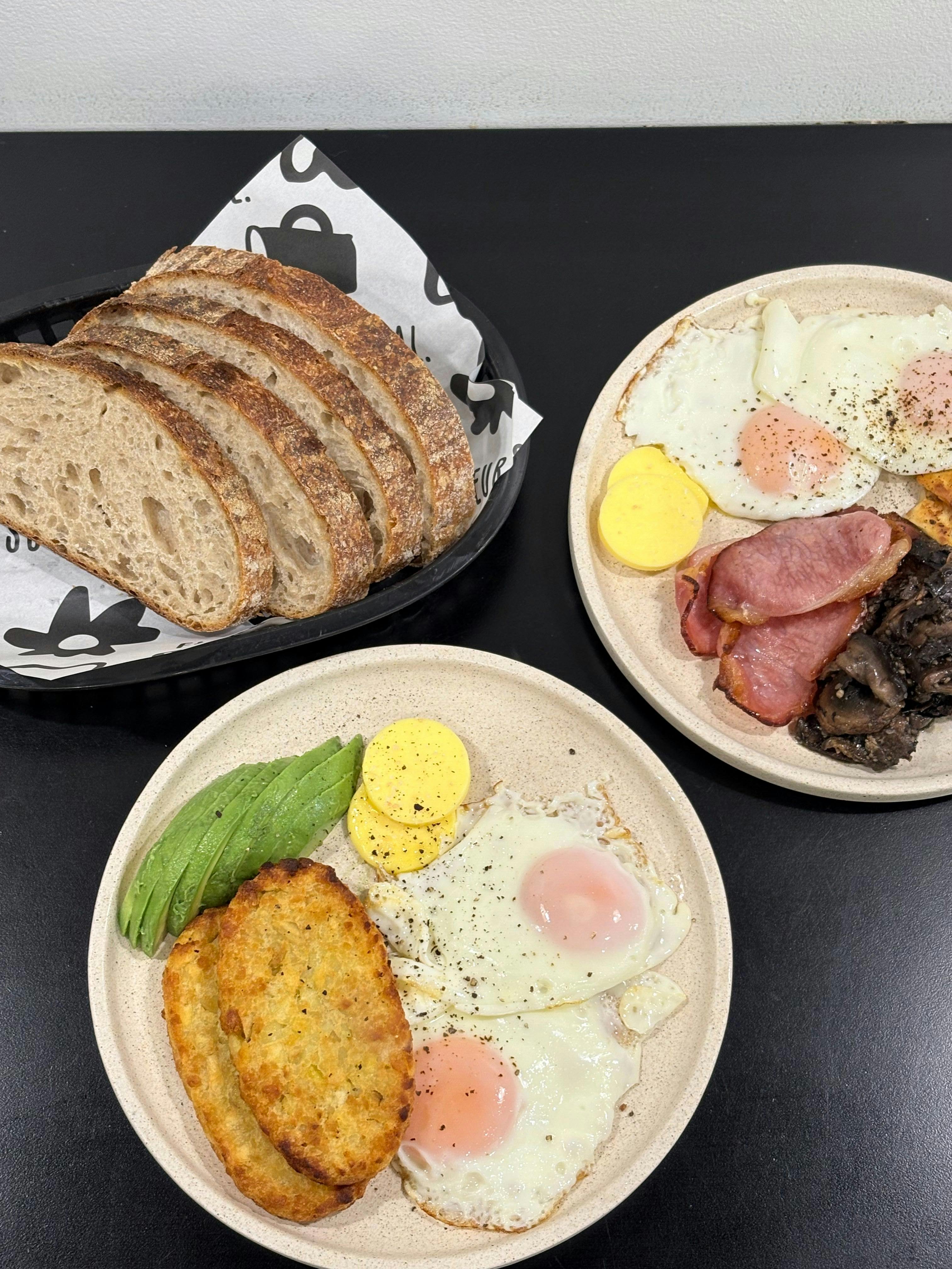 Fried eggs, sourdough toast, avocado, butter, mushrooms and bacon