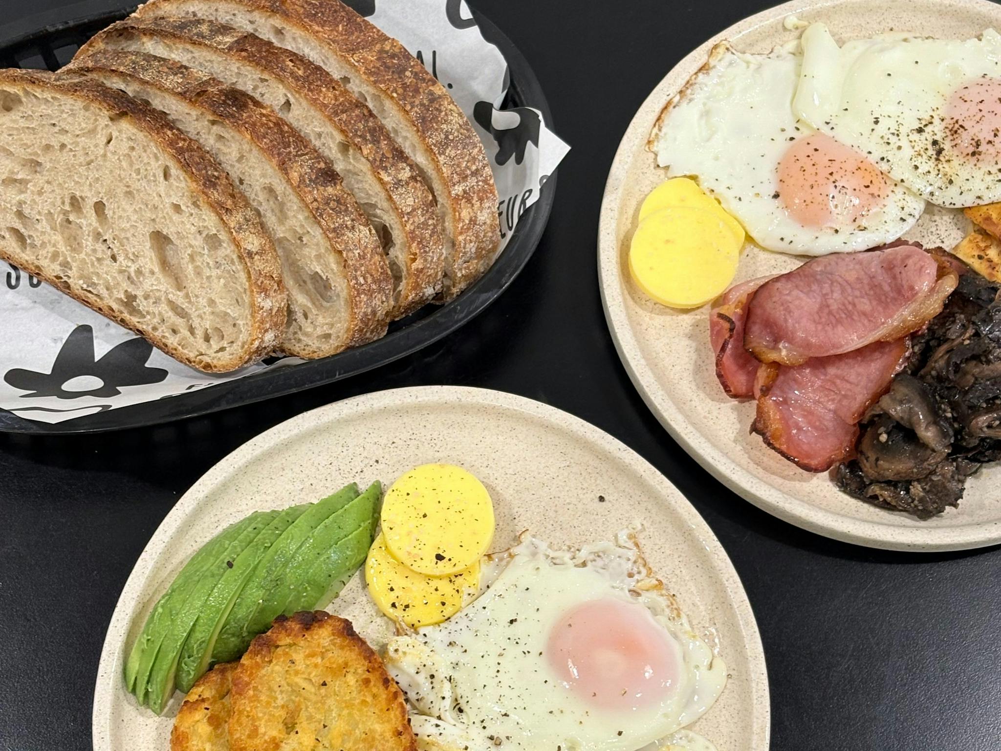 Fried eggs, sourdough toast, avocado, butter, mushrooms and bacon