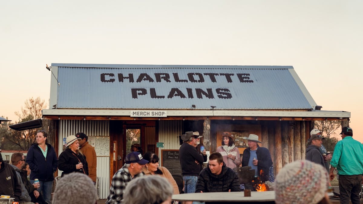 Guests gathered around the fire at Charlotte Plains bar and merch hut