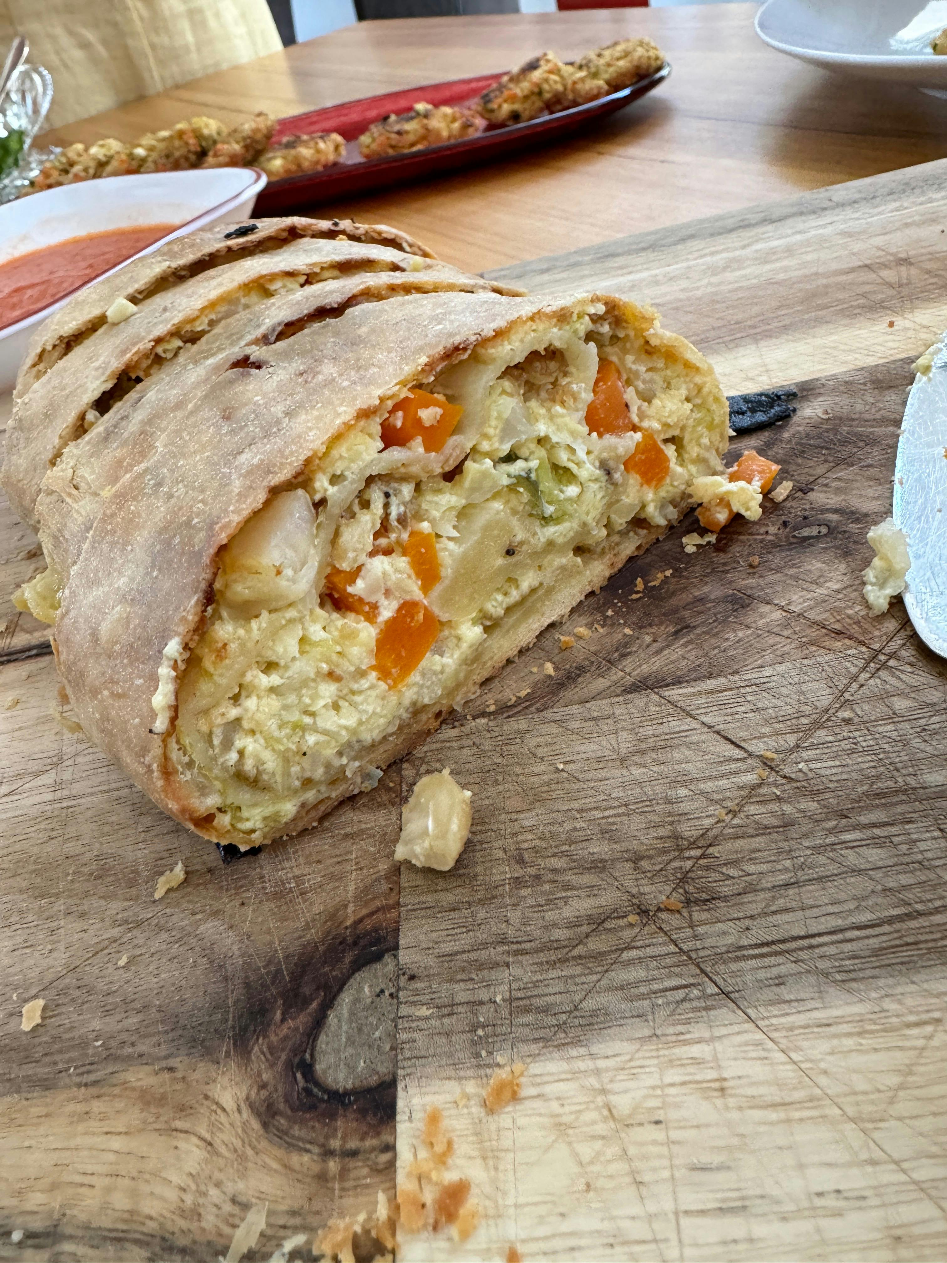 Sliced homemade strudel filled with colourful seasonal vegetables