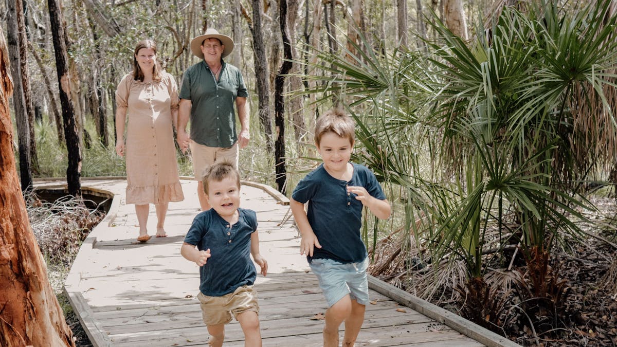 Family walking along the bushland boardwalk at Traveller's Rest 1770 BushTracks Eco Tours in 1770