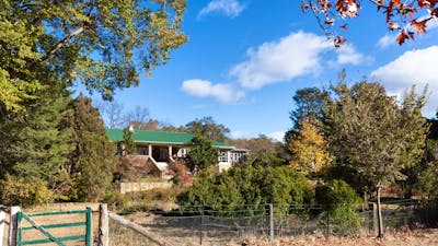 view of a heritage listed homestead amidst an autumnal garden