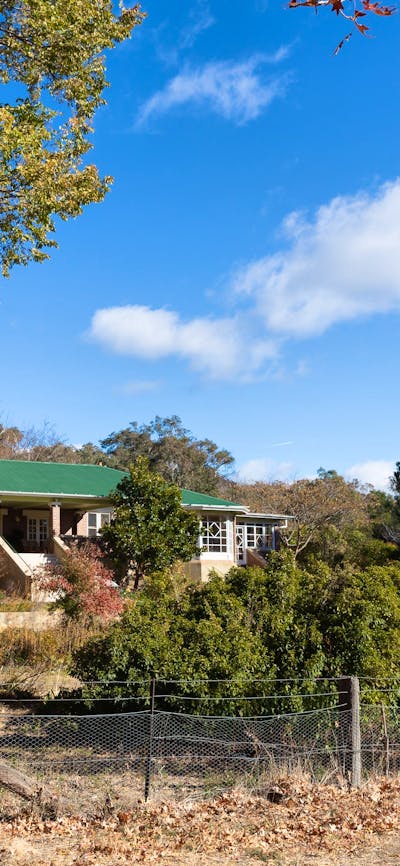 view of a heritage listed homestead amidst an autumnal garden