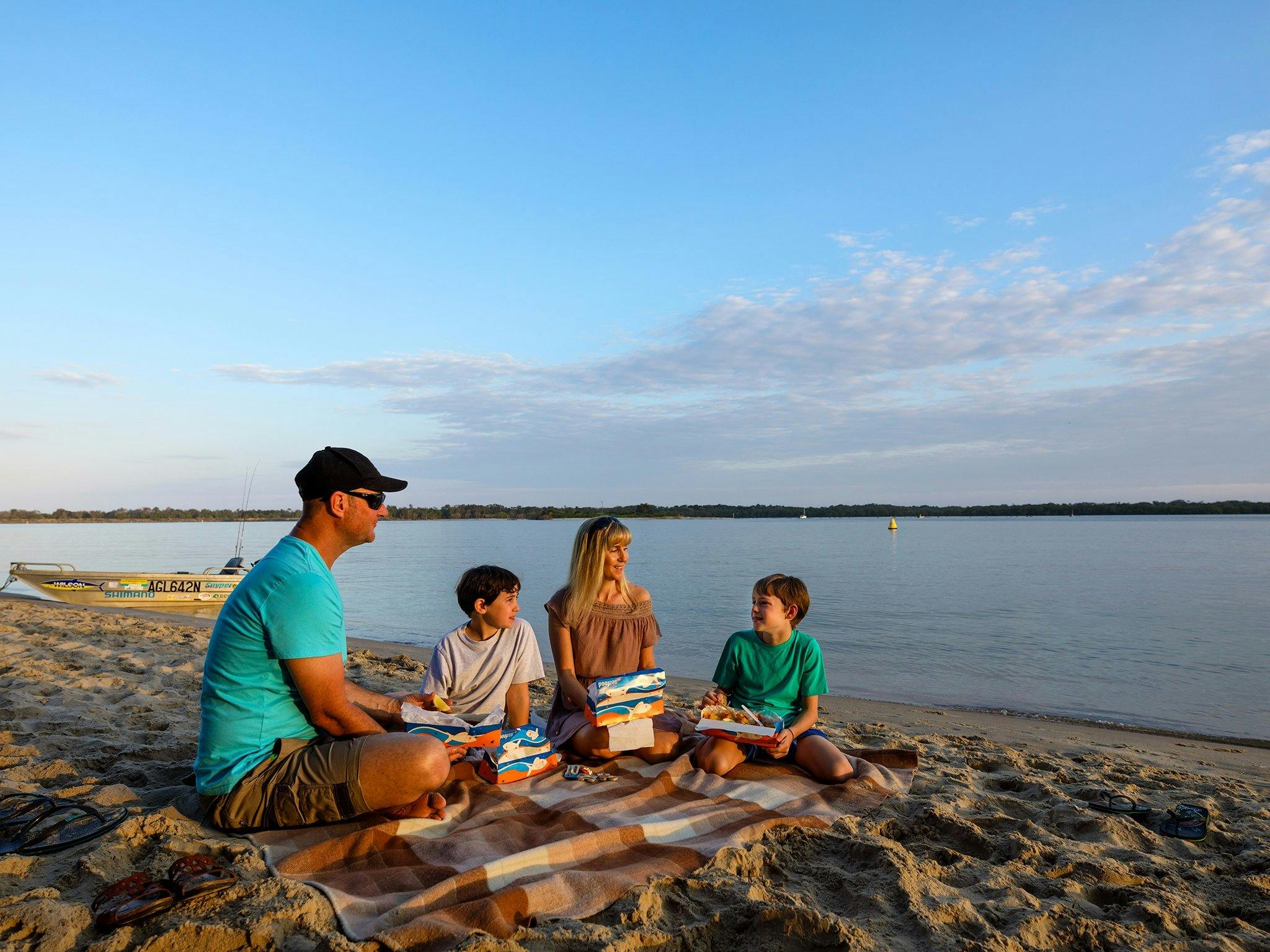 Family picnic by the Richmond River at sunset