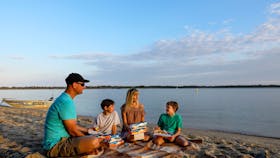 Family picnic by the Richmond River at sunset