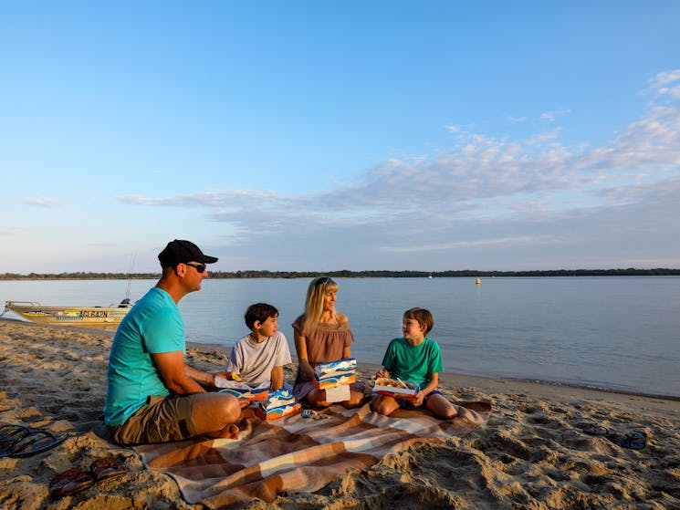 Family picnic by the Richmond River at sunset