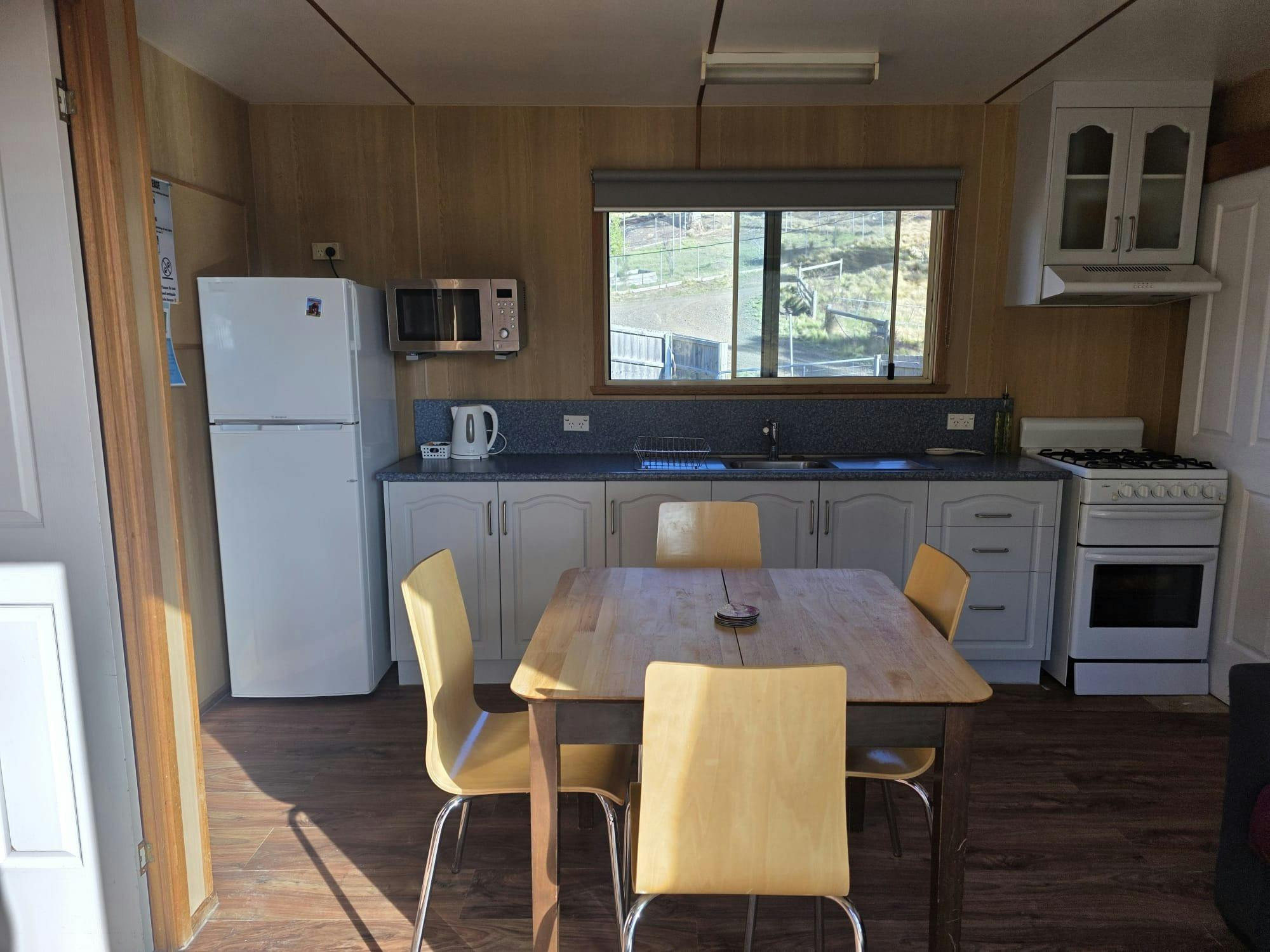 Fully equipped kitchen and dining area with views of the surrounding bushland