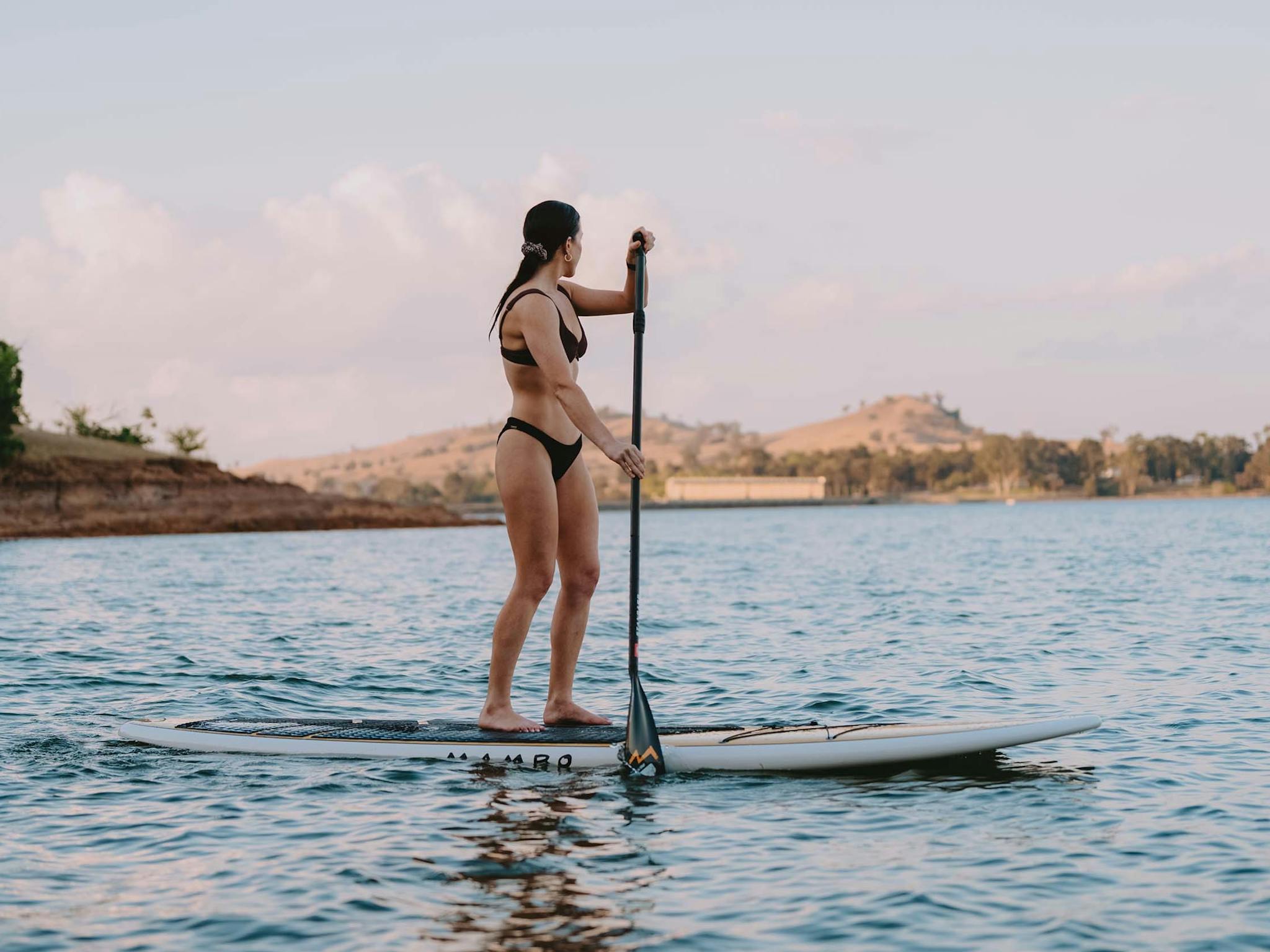 Woman standup paddleboarding at Lake Hume Dam Wall