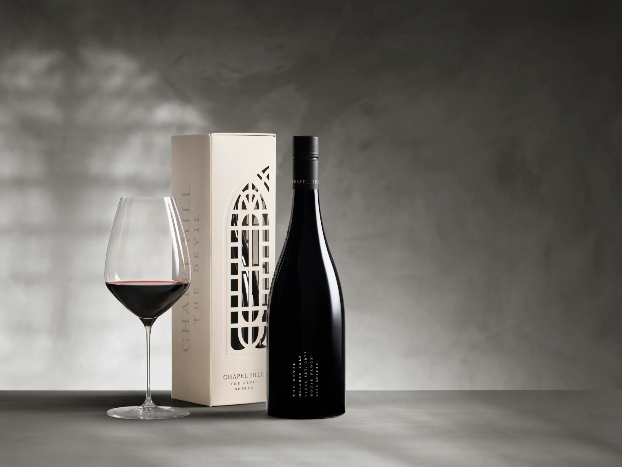 An elegant, screen printed wine bottle with a laser cut white box showing the chapel hill window