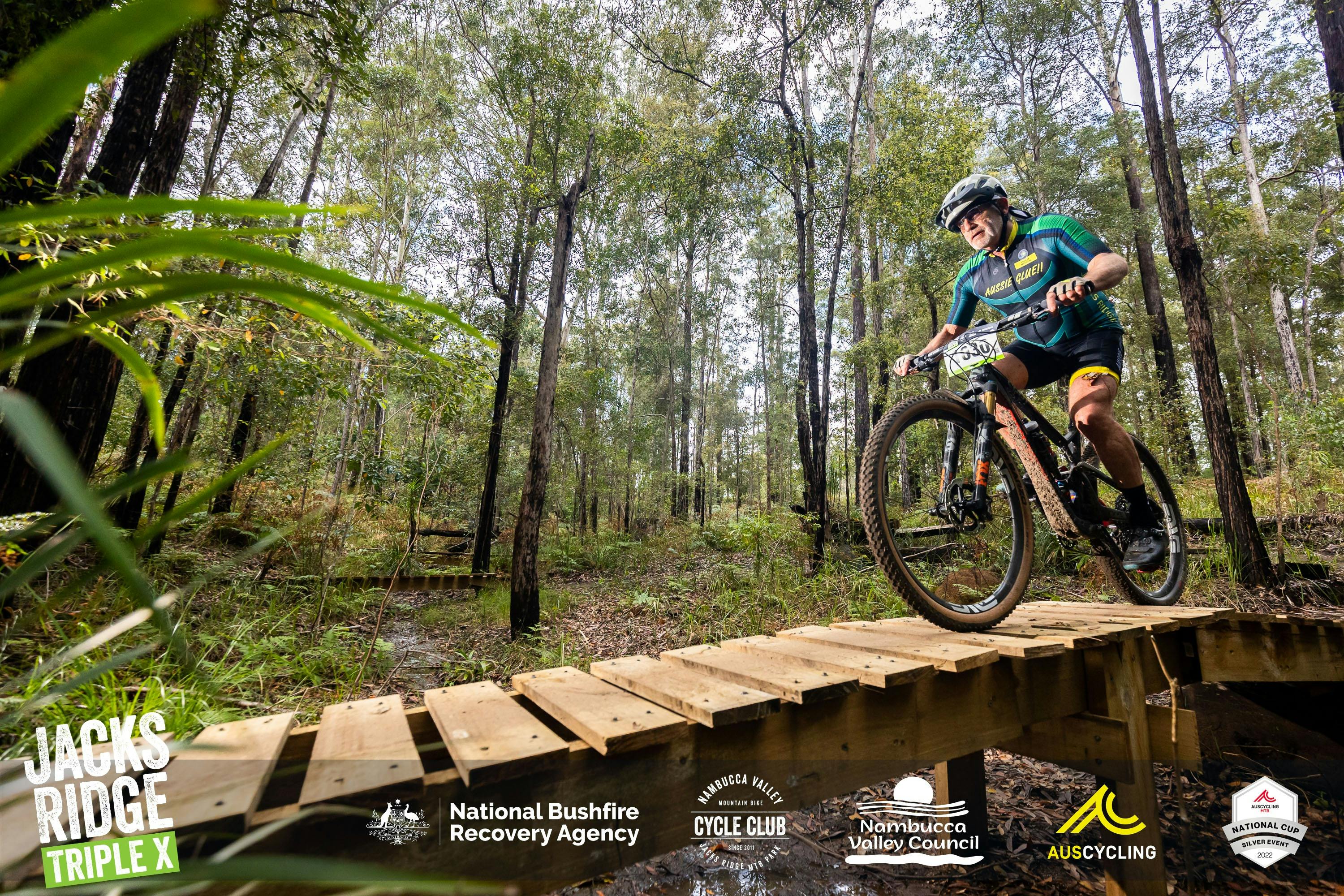 Man on a mountain bike riding down a wooden ramp at XXX All Ages Event