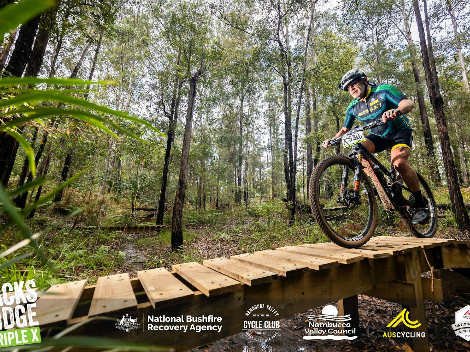 Man on a mountain bike riding down a wooden ramp at XXX All Ages Event