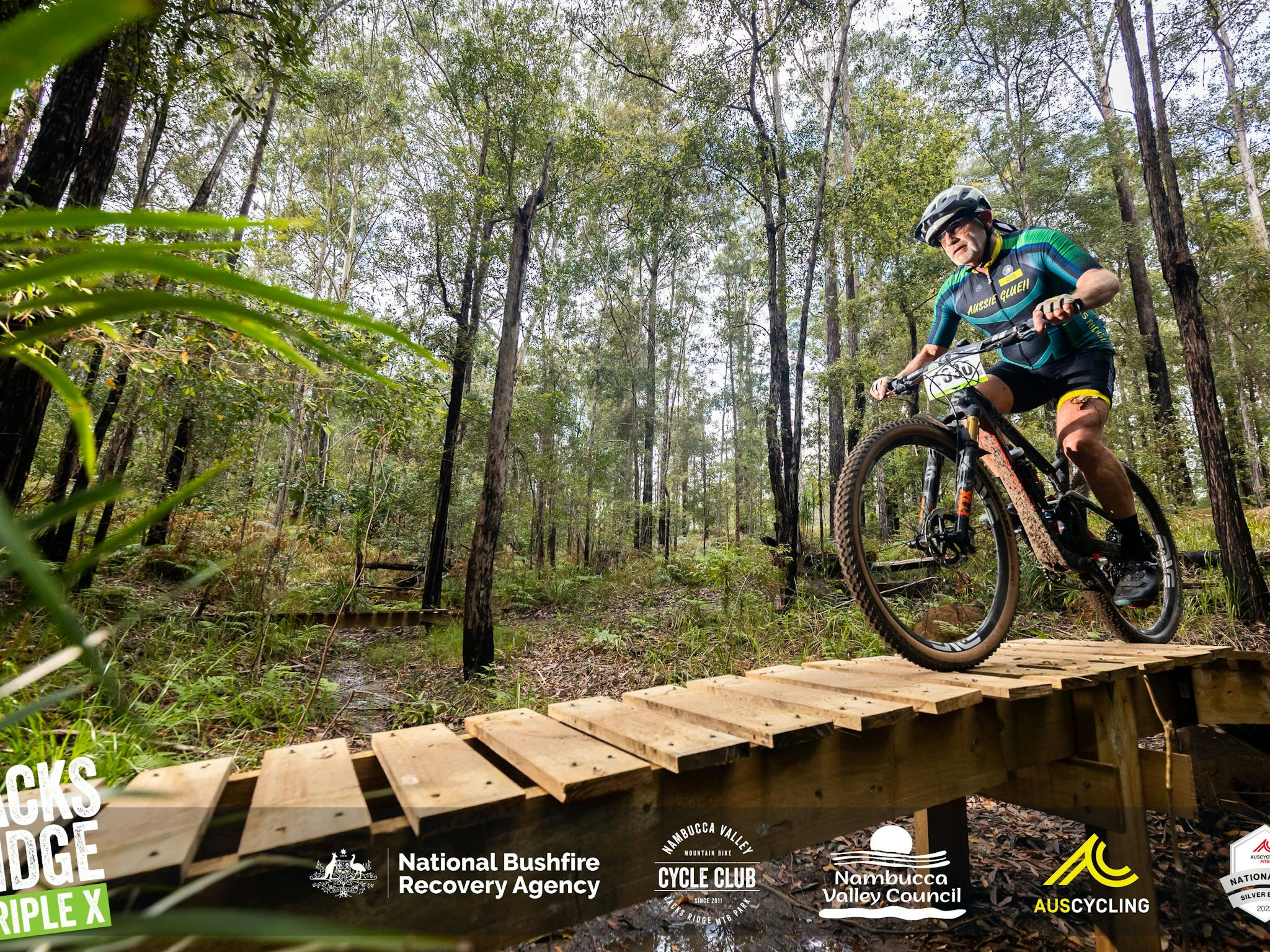 Man on a mountain bike riding down a wooden ramp at XXX All Ages Event