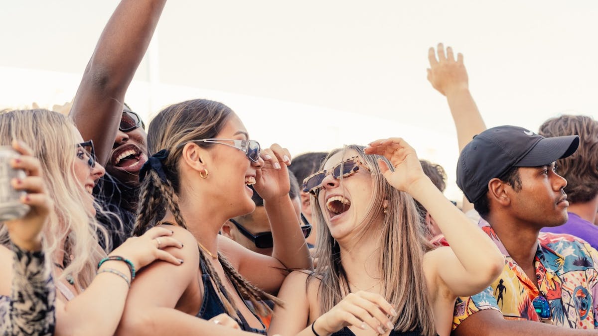 Two friends enjoying a concert in a crowd of people