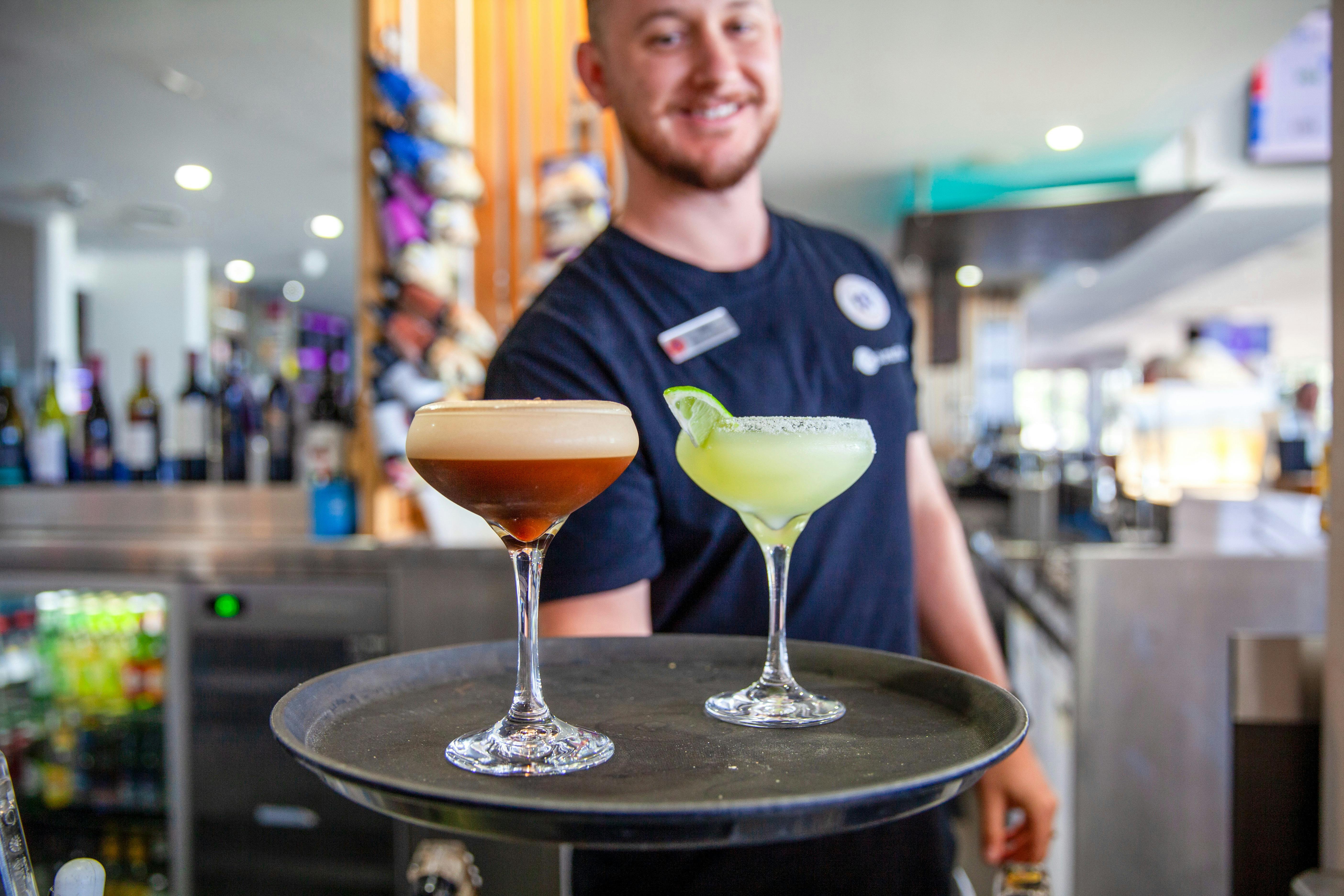 Photo of friendly bartender serving delicious cocktails