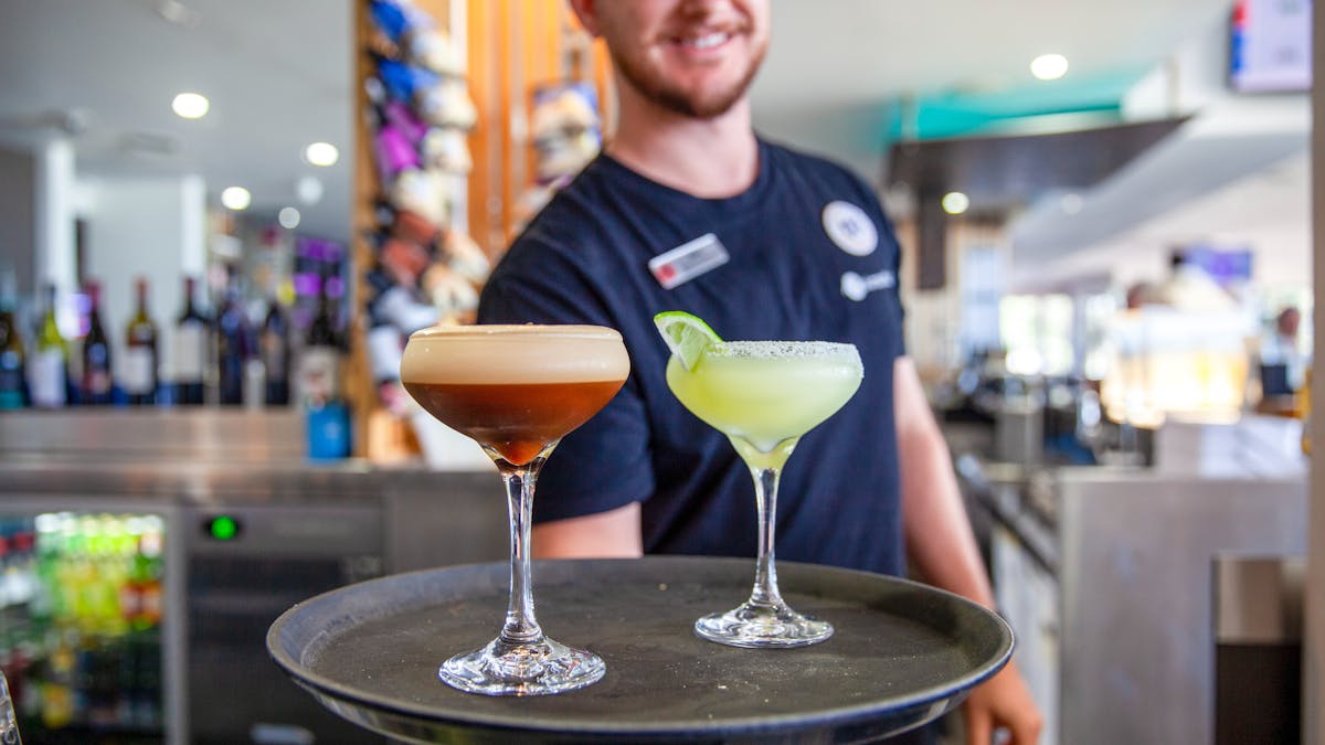 Photo of friendly bartender serving delicious cocktails
