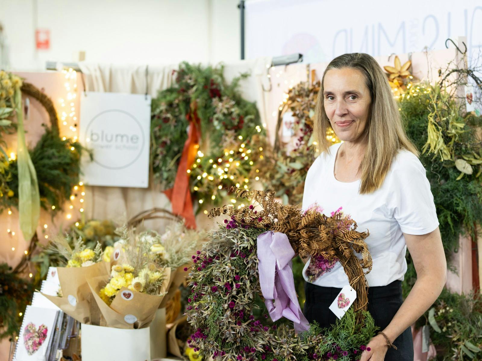 Blume Flower School holding a wreath