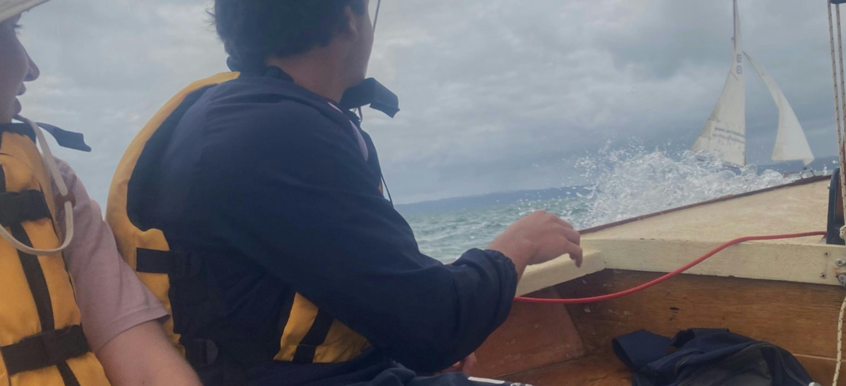 A kid having  a sailing lesson on the water