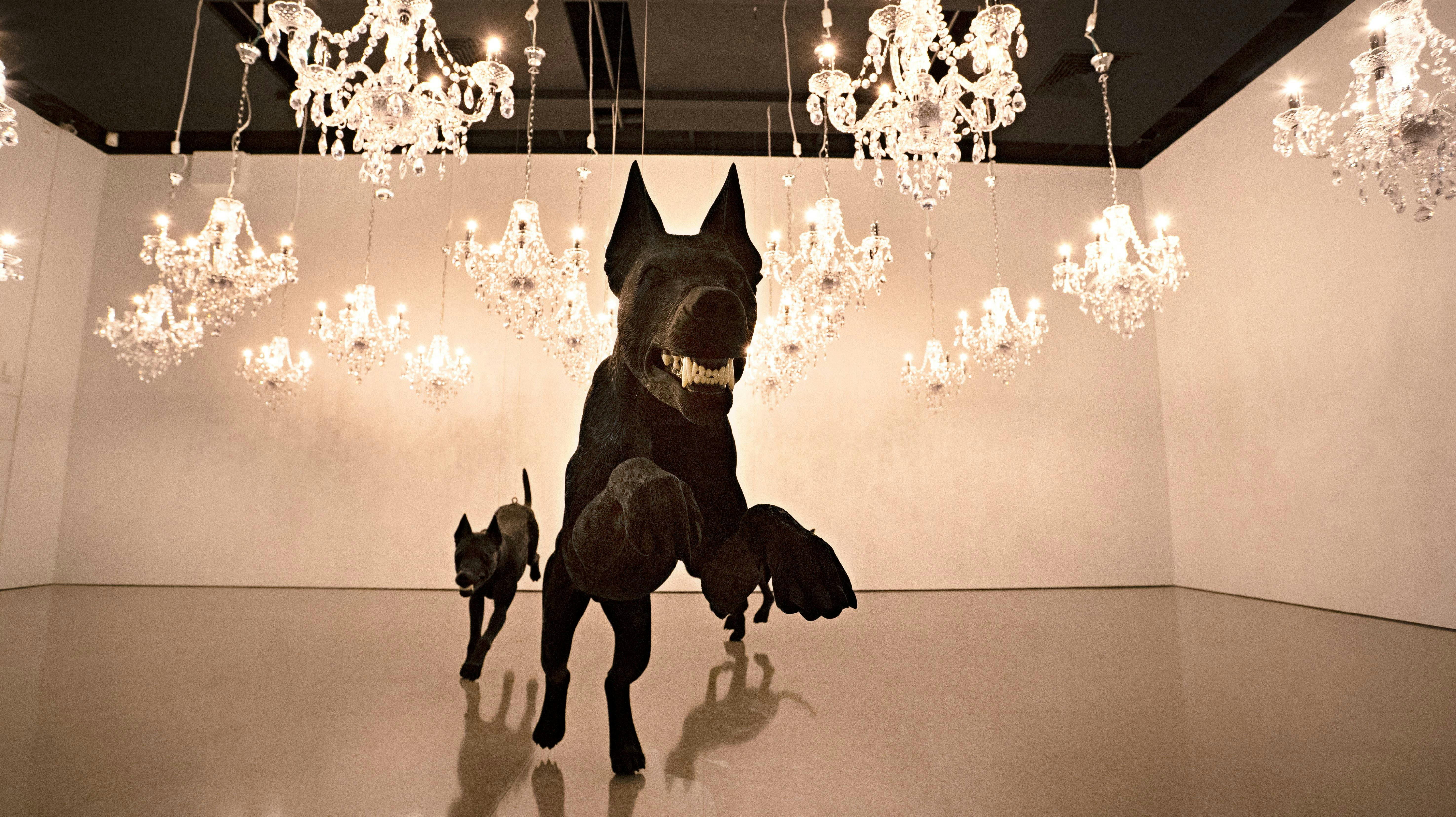 Image showing installed artwork of large dog statues and chandeliers.