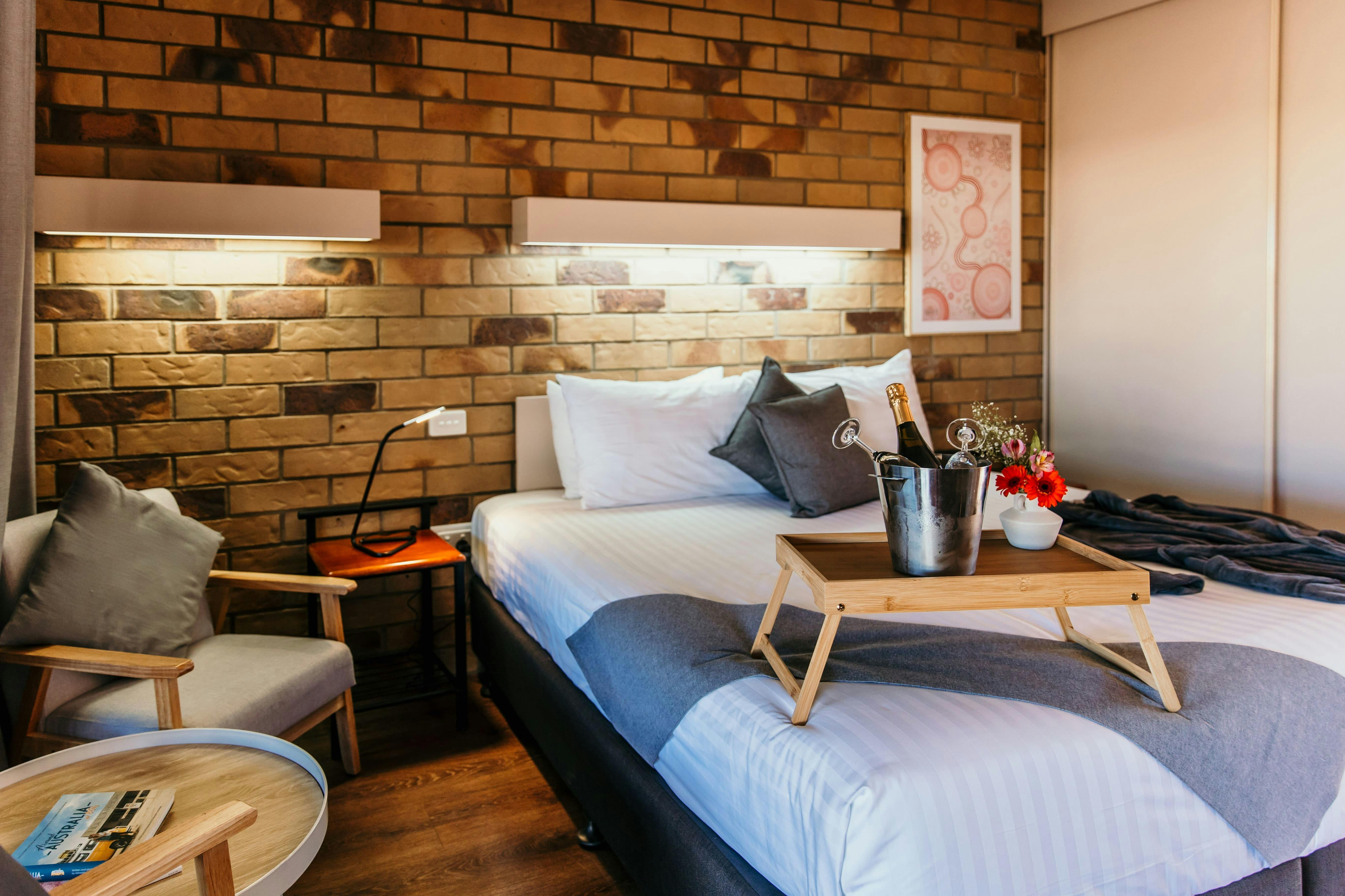 King bed with a robe, cheese platter and champagne ice bucket.